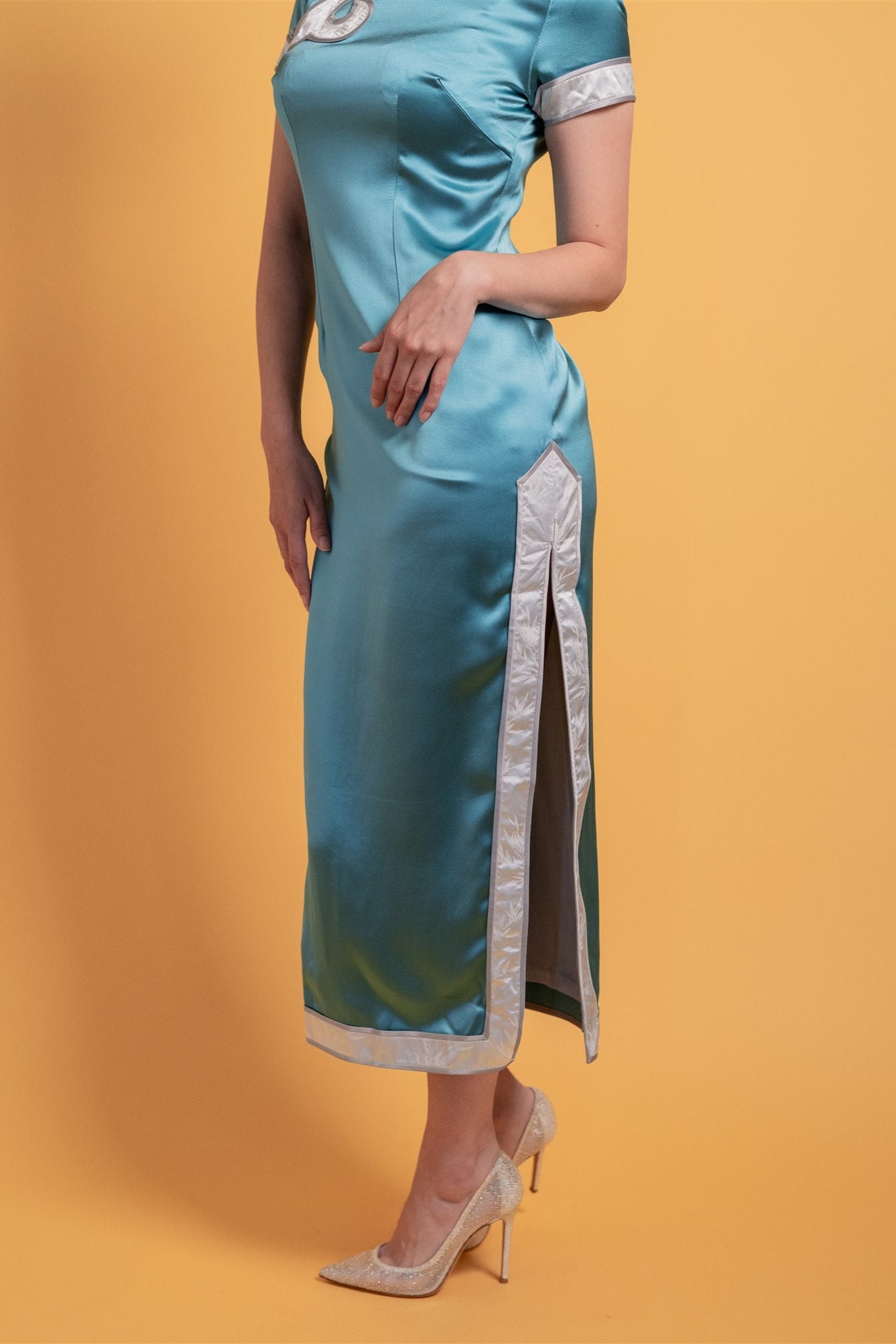 Close-up of silver piping on teal silk cheongsam