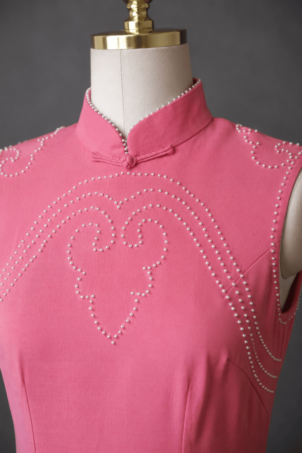 Close up of hand sewn pearl heart motif and mandarin collar on baby pink silk crepe Qipao — pearl embroidery detail by JINZA Oriental Couture, Los Angeles