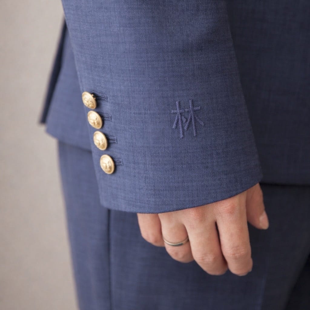 Custom Zhongshan suit sleeve detail showing hand embroidered family name in Chinese characters and gold buttons, JINZA Los Angeles