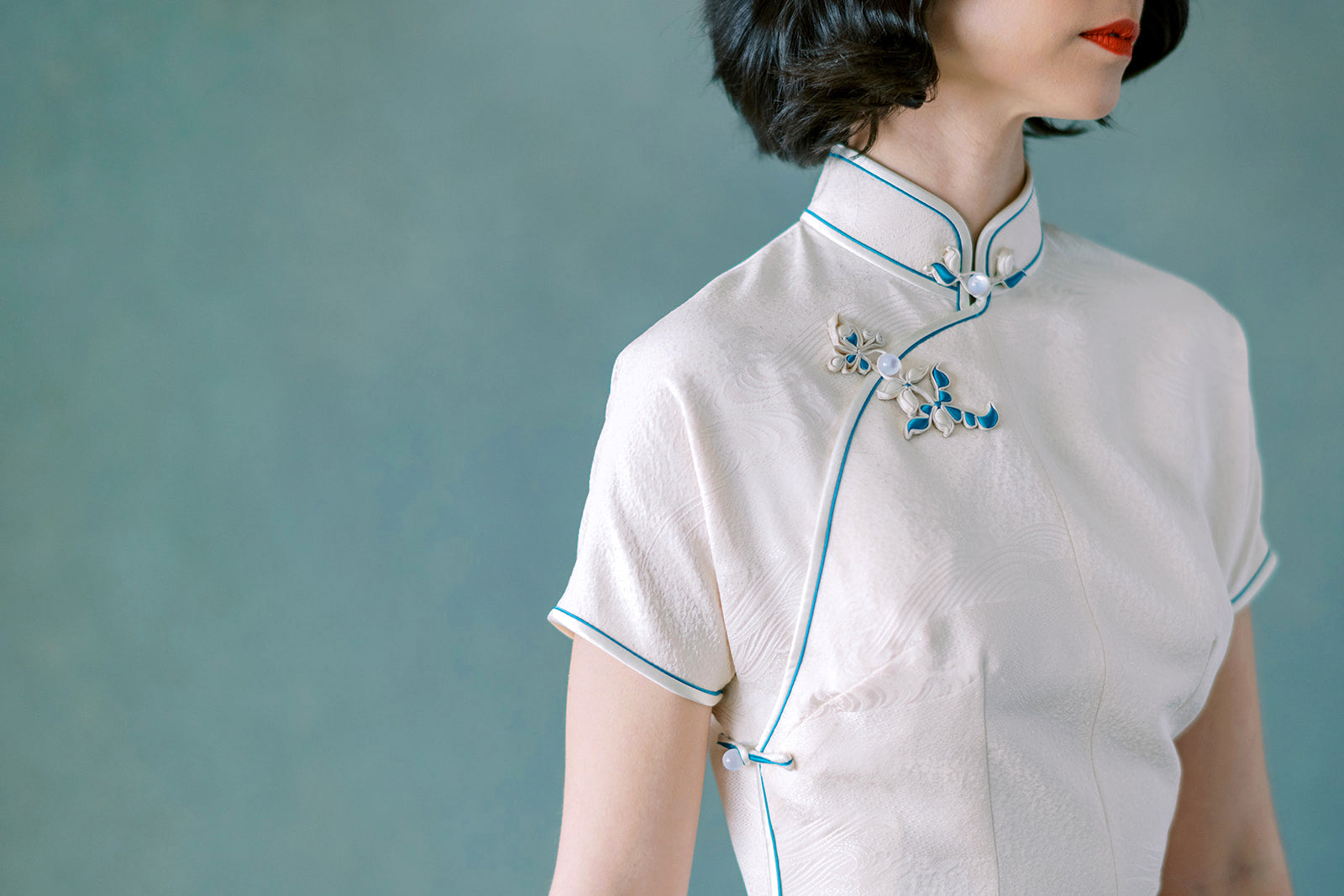 Side view of traditional Pankou buttons on white Chinese dress