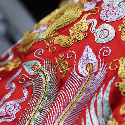 A family name is embroidered on a red Chinese wedding dress Qun Kwa