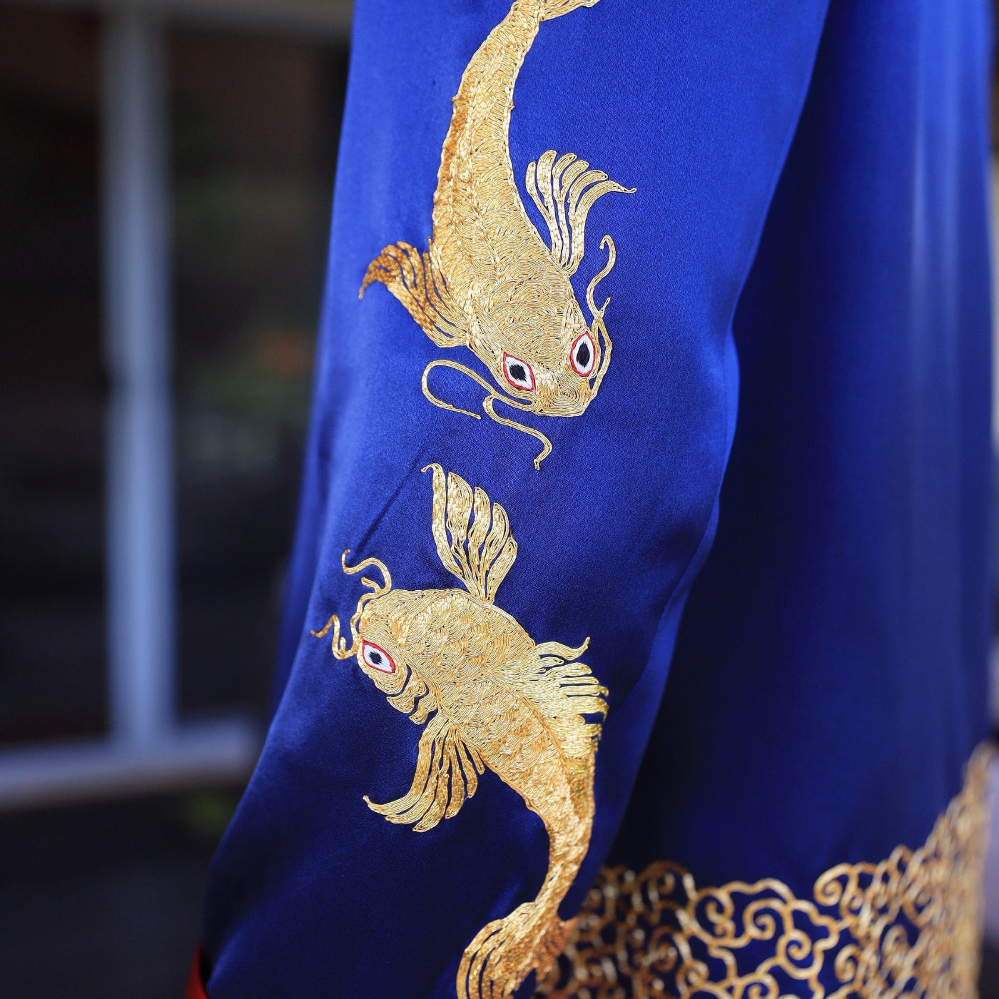 Gold Koi fishes symbolizing prosperity and resilience on royal blue silk tang suit for groom