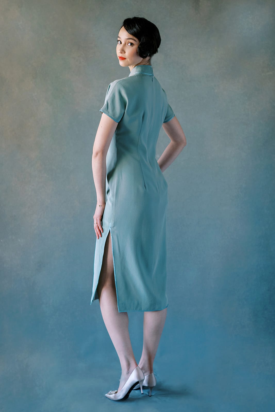 Back view of green silk Cheongsam dress with orchid embroidery and dark green trim.