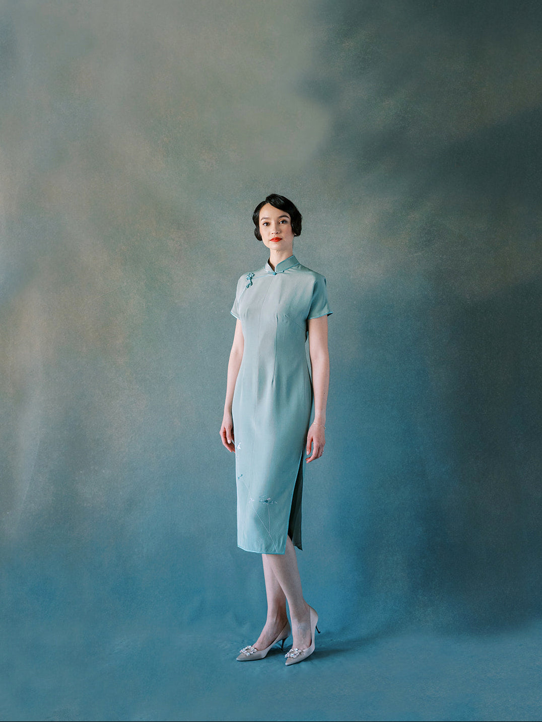 Front view of green silk Qipao with hand-embroidered white orchids.