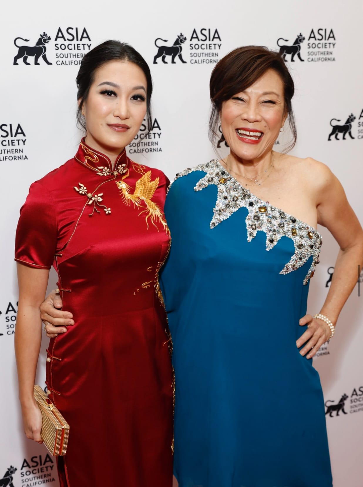 Actress Kara Wang wearing a red silk phoenix Qipao by JINZA Oriental Couture with Oscar President Janet Yang at the Asia Society Gala in Los Angeles.