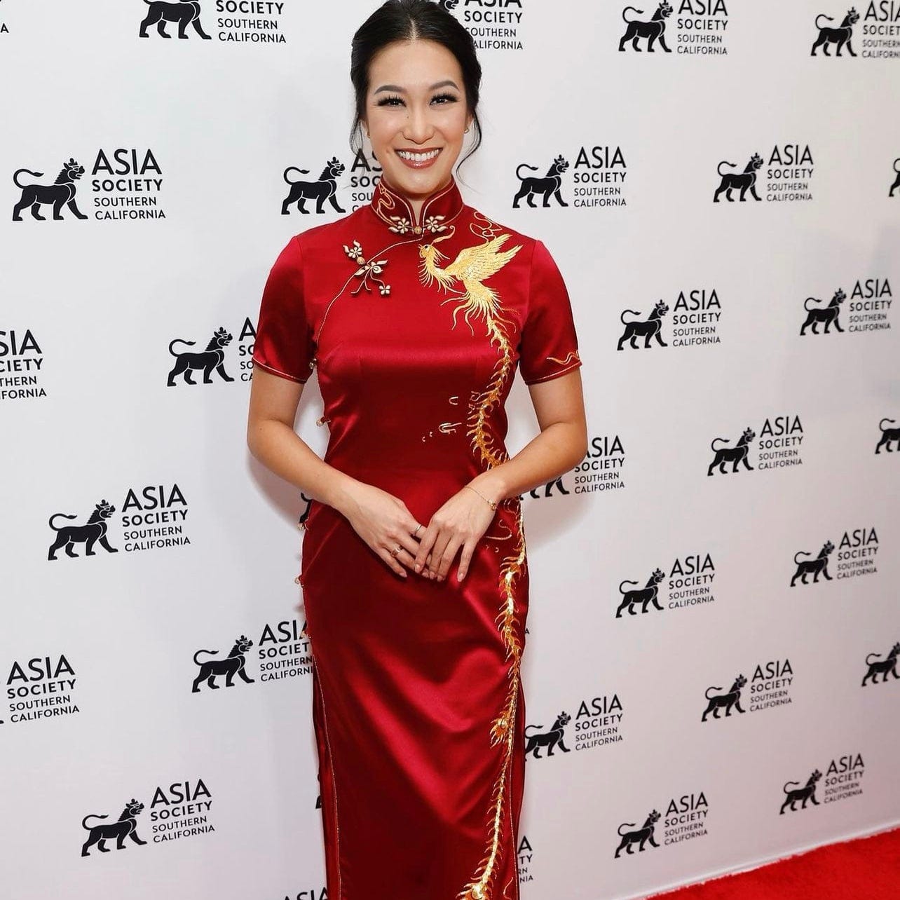 Kara Wang in a red silk wedding Qipao with flying phoenix embroidery at her multicultural ceremony