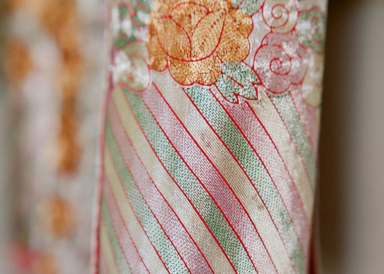 Hand-embroidered lucky clouds on neckline and trim of traditional Qun Kwa for harmony and peace