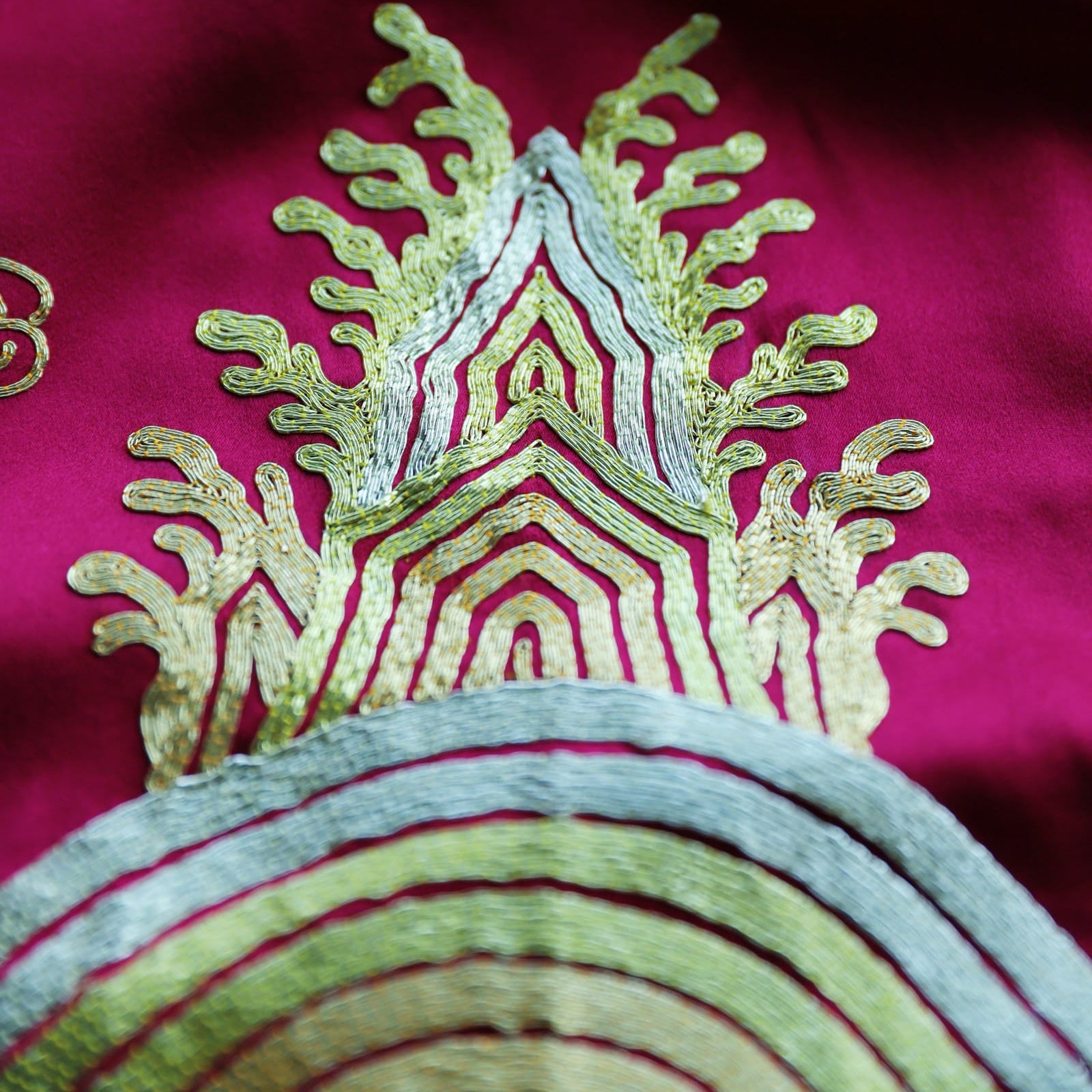 Lucky sea-wave embroidery detail on the fully embroidered train of red silk Qipao.