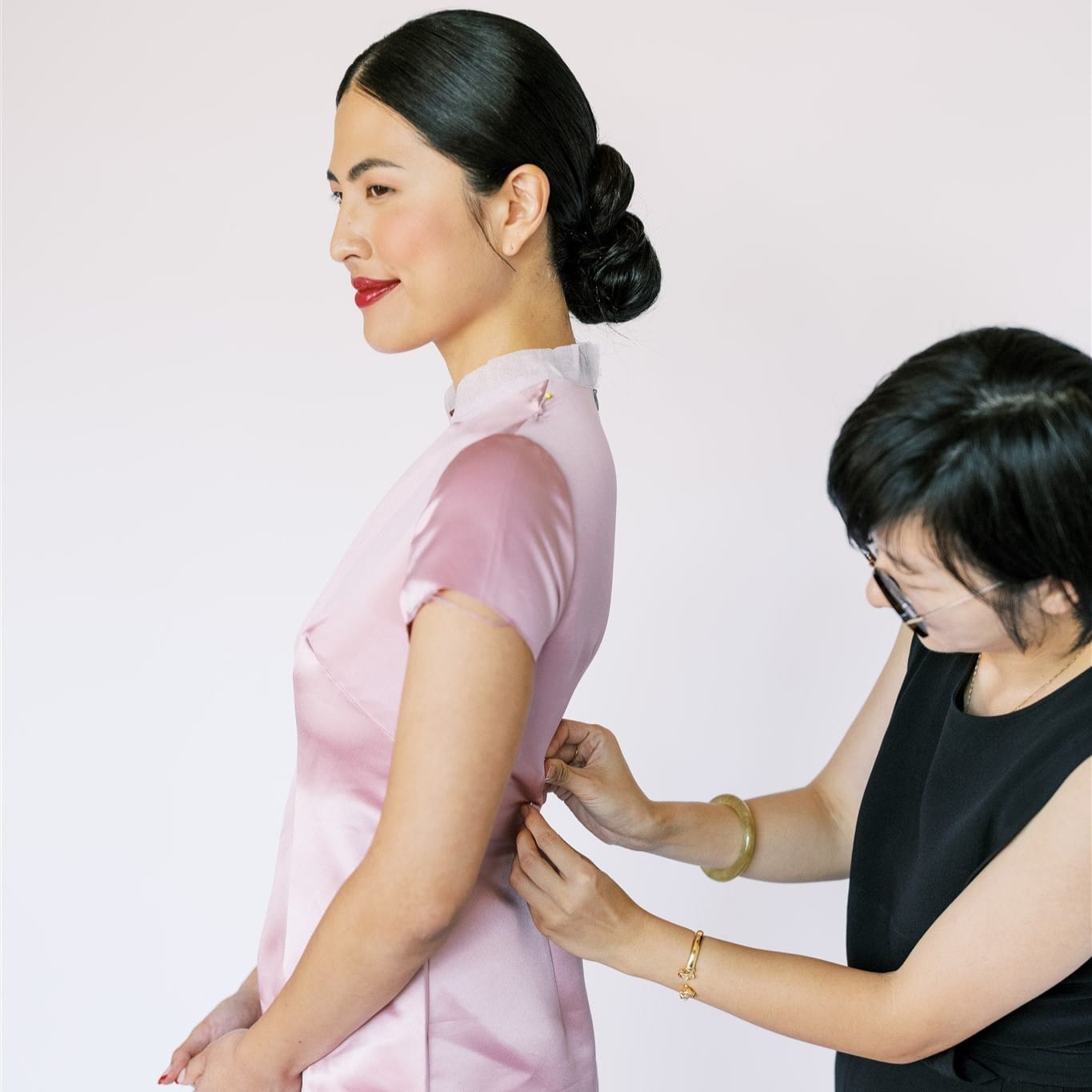 Grace teaching embroidery to a young Asian American apprentice