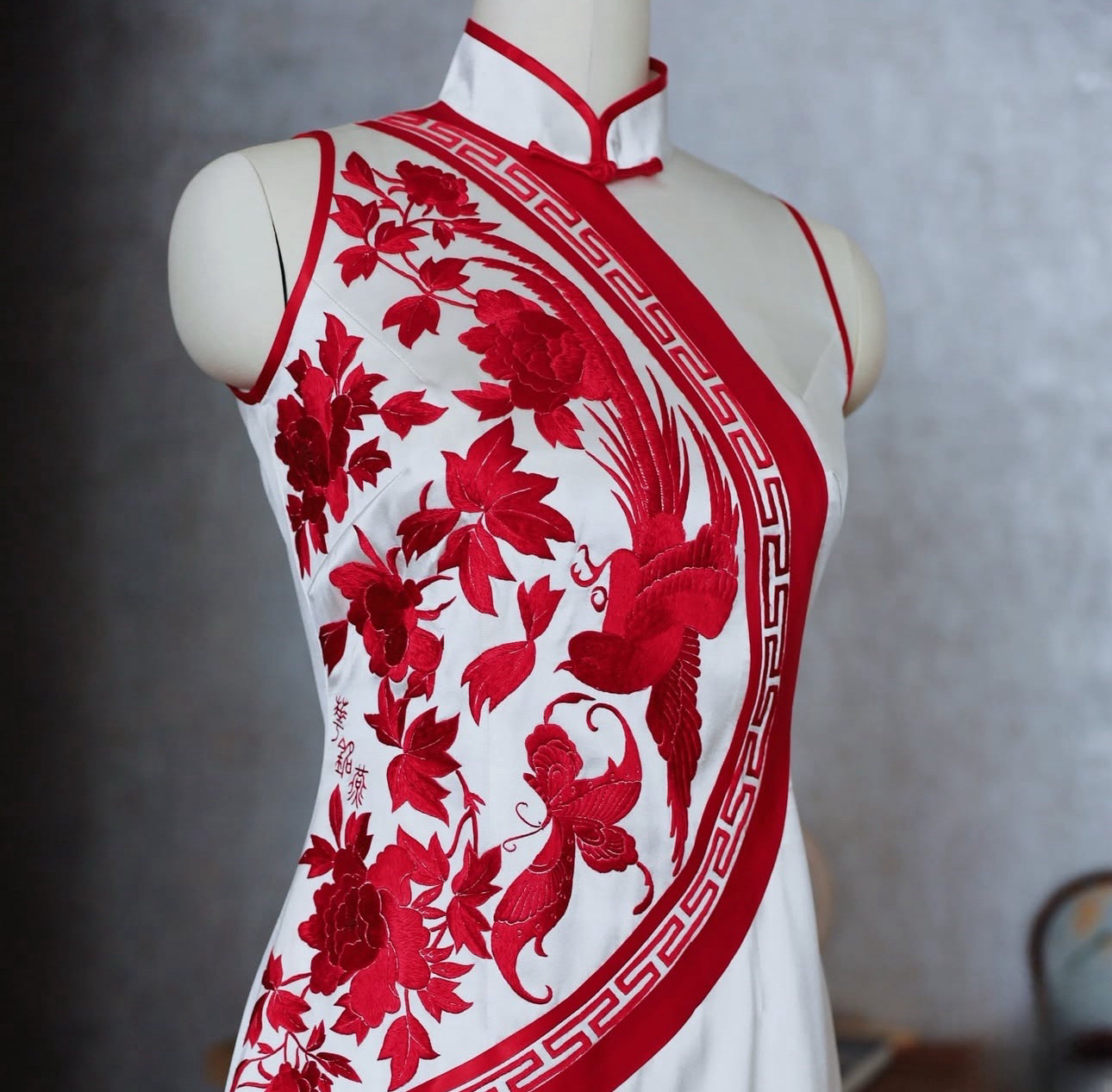 Modern Qipao Cheongsam in white silk with red embroidery of bird, peony, and butterfly motifs, featuring a halter neckline — an elegant Chinese dress blending tradition and modern style.
