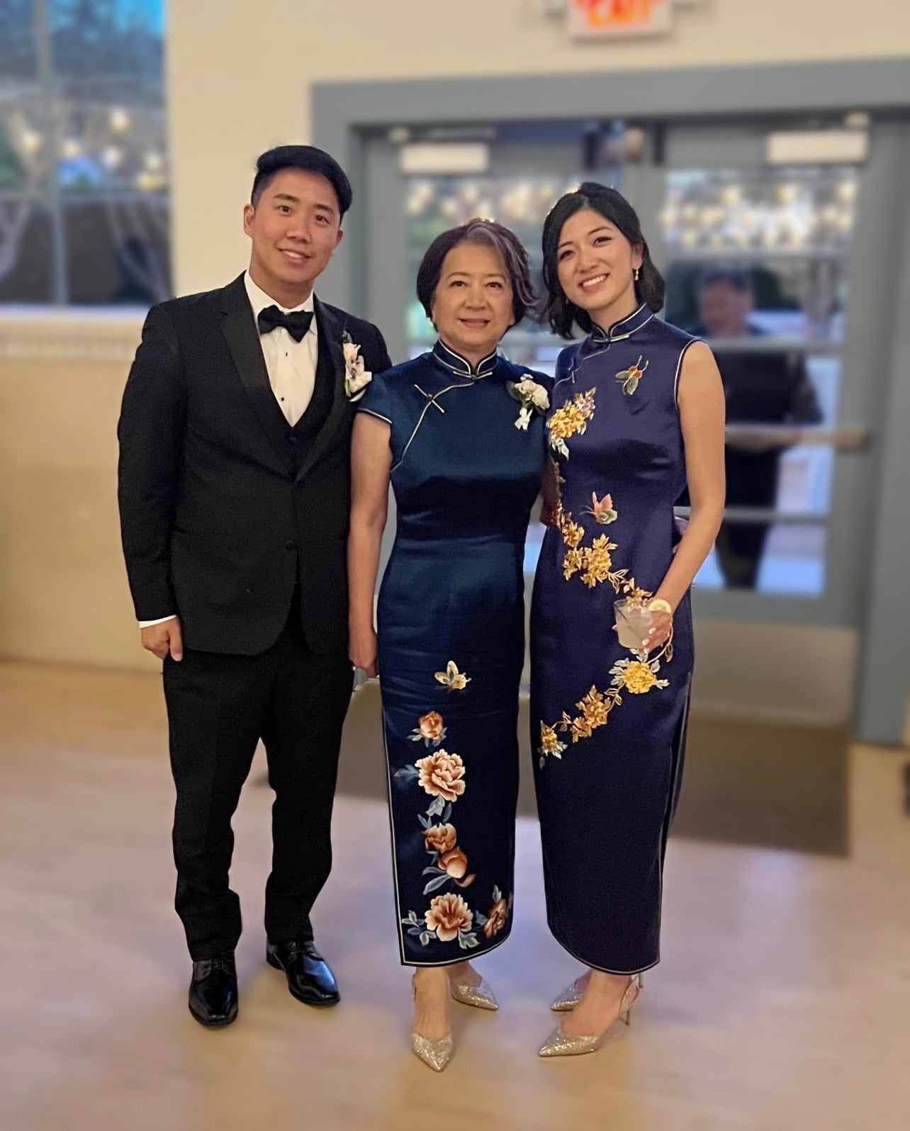 Real bride and mother wearing matching navy blue Qipao with Panjin embroidered peonies designed by JINZA Oriental Couture for Chinese wedding tea ceremony