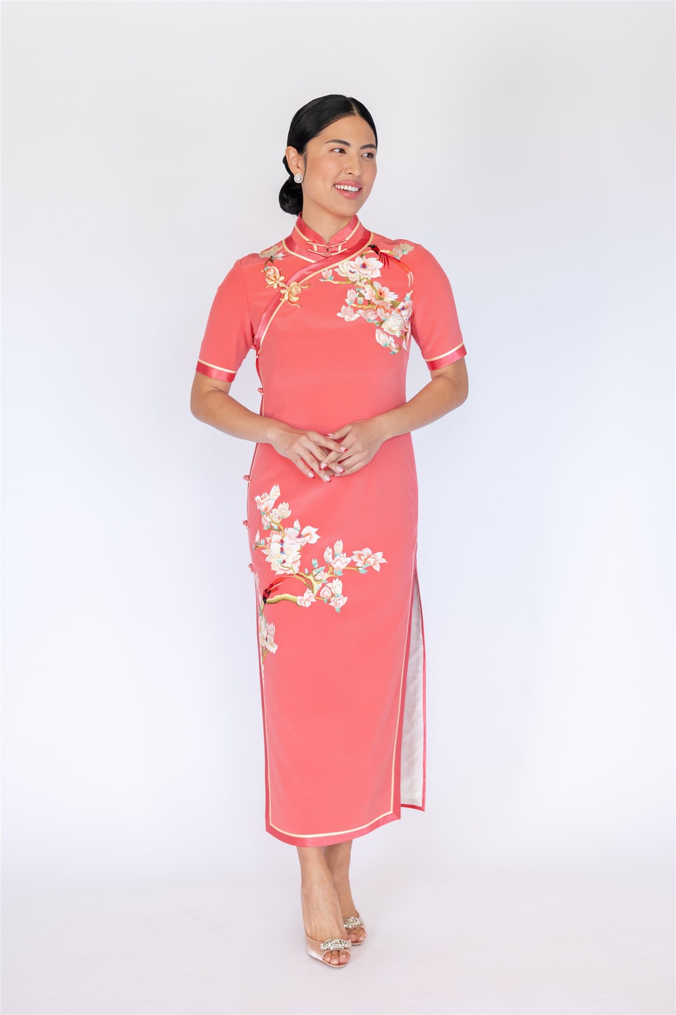 Orange pink silk Cheongsam with cherry blossom embroidery and yellow trim, front view.