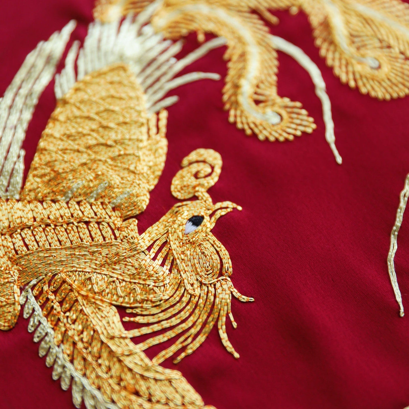 Gold phoenix hand embroidery on wedding Qipao symbolizing rebirth and femininity