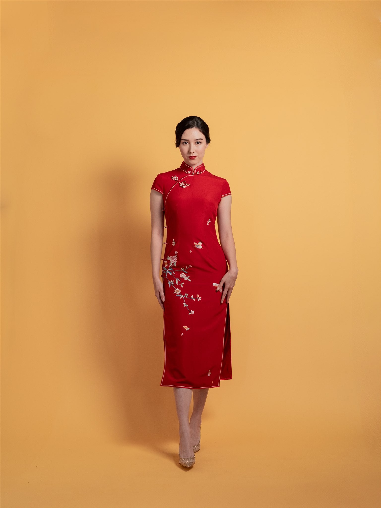 Front view of red cherry blossom Qipao Chinese wedding dress with butterfly embroidery.