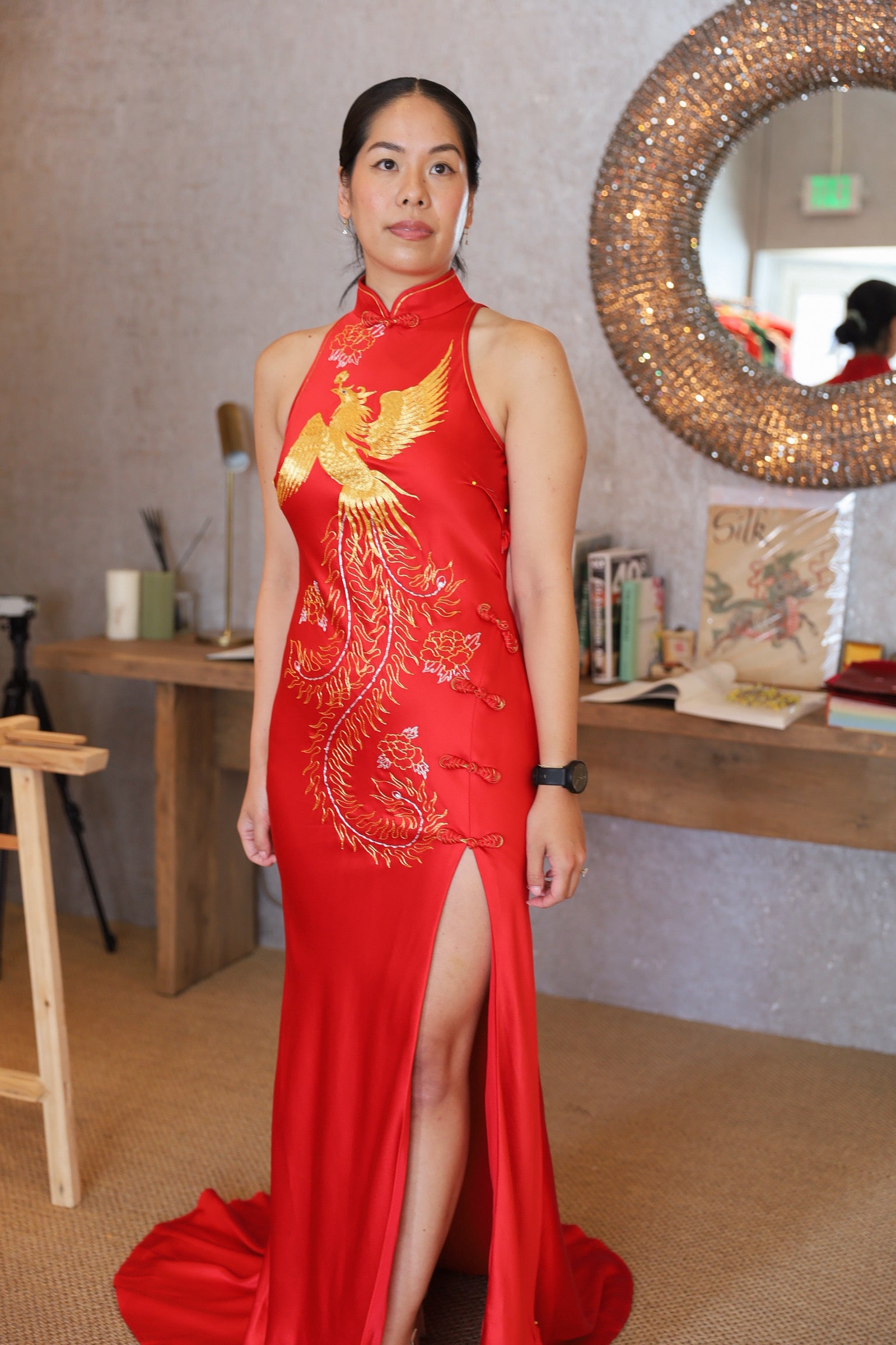Real bride wearing red modern chinese wedding Qipao dress with halter neckline and front slit with gold hand-embroidered phoenix.