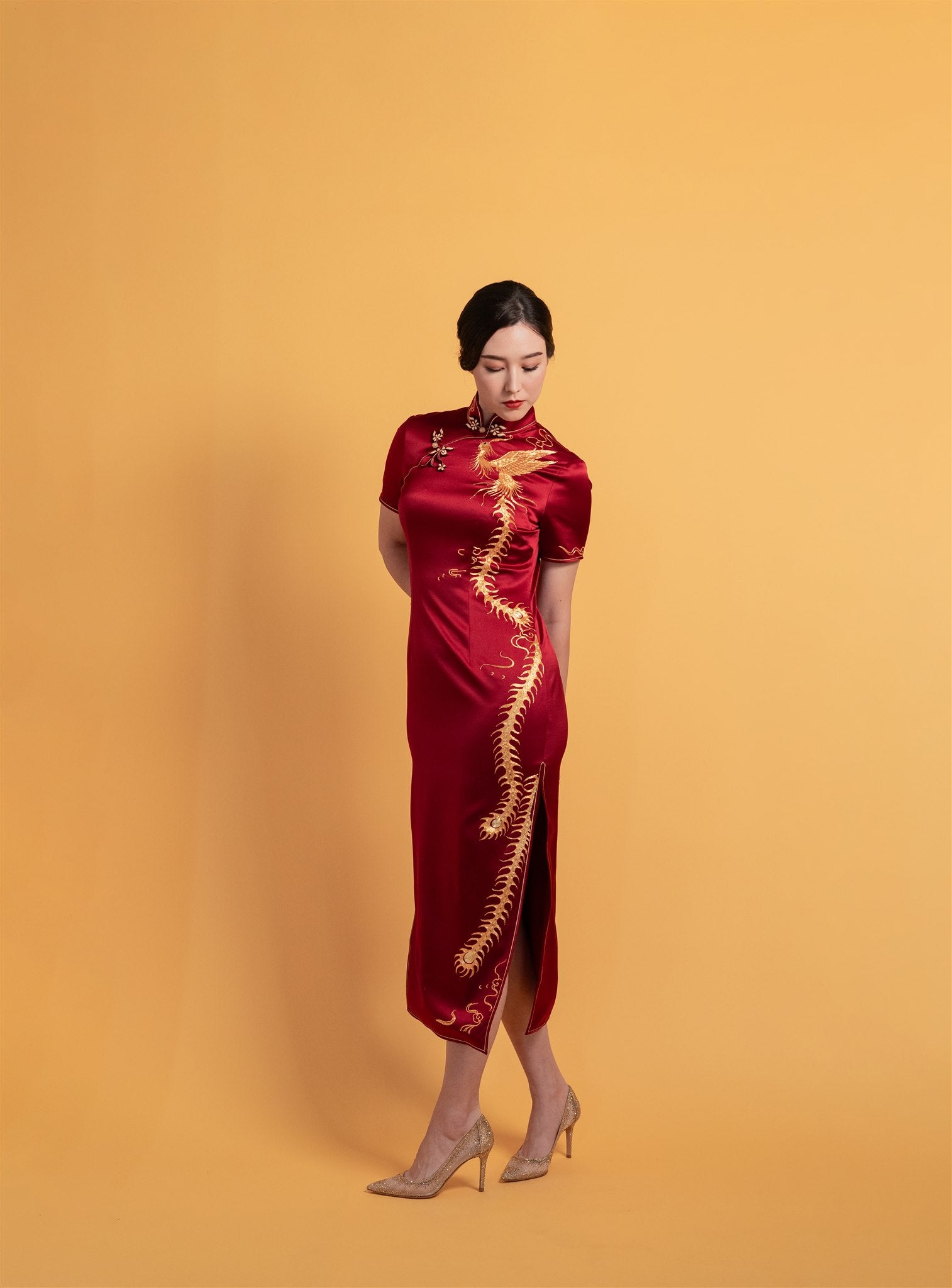 Front view of red phoenix Qipao Chinese wedding dress with hand-embroidered motif.