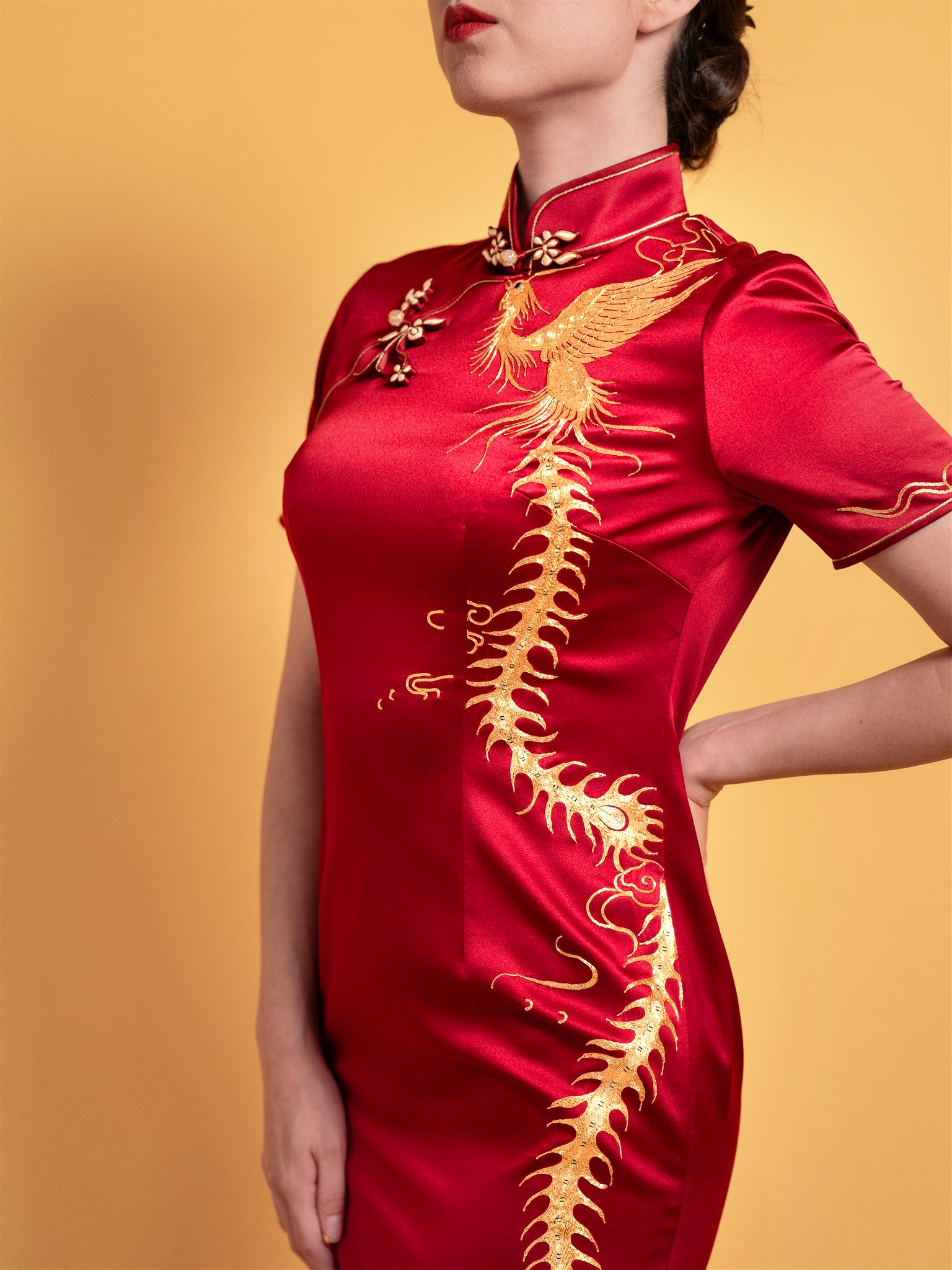 Hand-embroidered flying phoenix motif detail on red silk Qipao Chinese wedding dress.