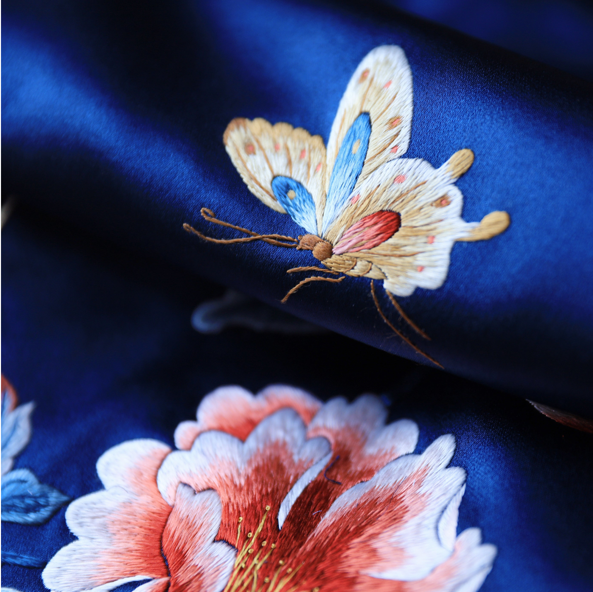 blue silk qipao with hand embroidered butterfly and peony flower detail