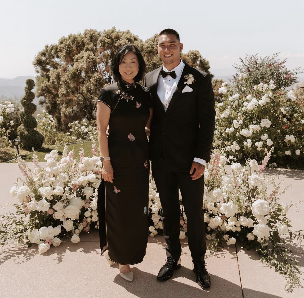 Mother of NFL Super Bowl Champion Taylor Rapp wearing a black Qipao with eight butterfly embroidery at his wedding