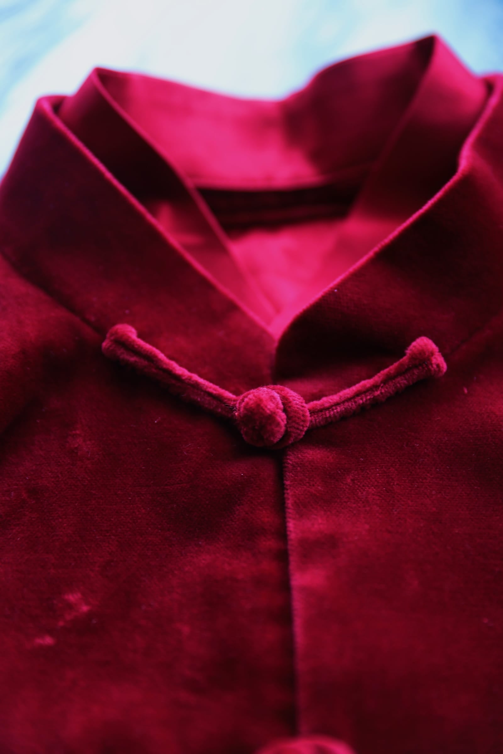 Handmade pankou knot closures on wine red silk velvet Tang suit jacket.