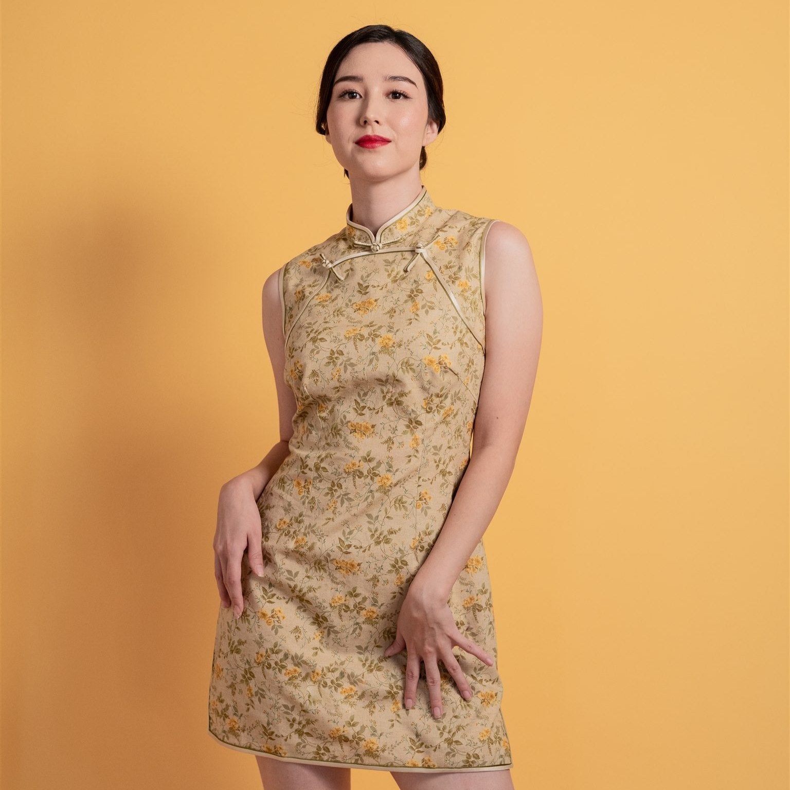 Close-up of the mandarin neckline and front button details on the beige sleeveless modern Cheongsam dress, crafted for party style and daily wear.