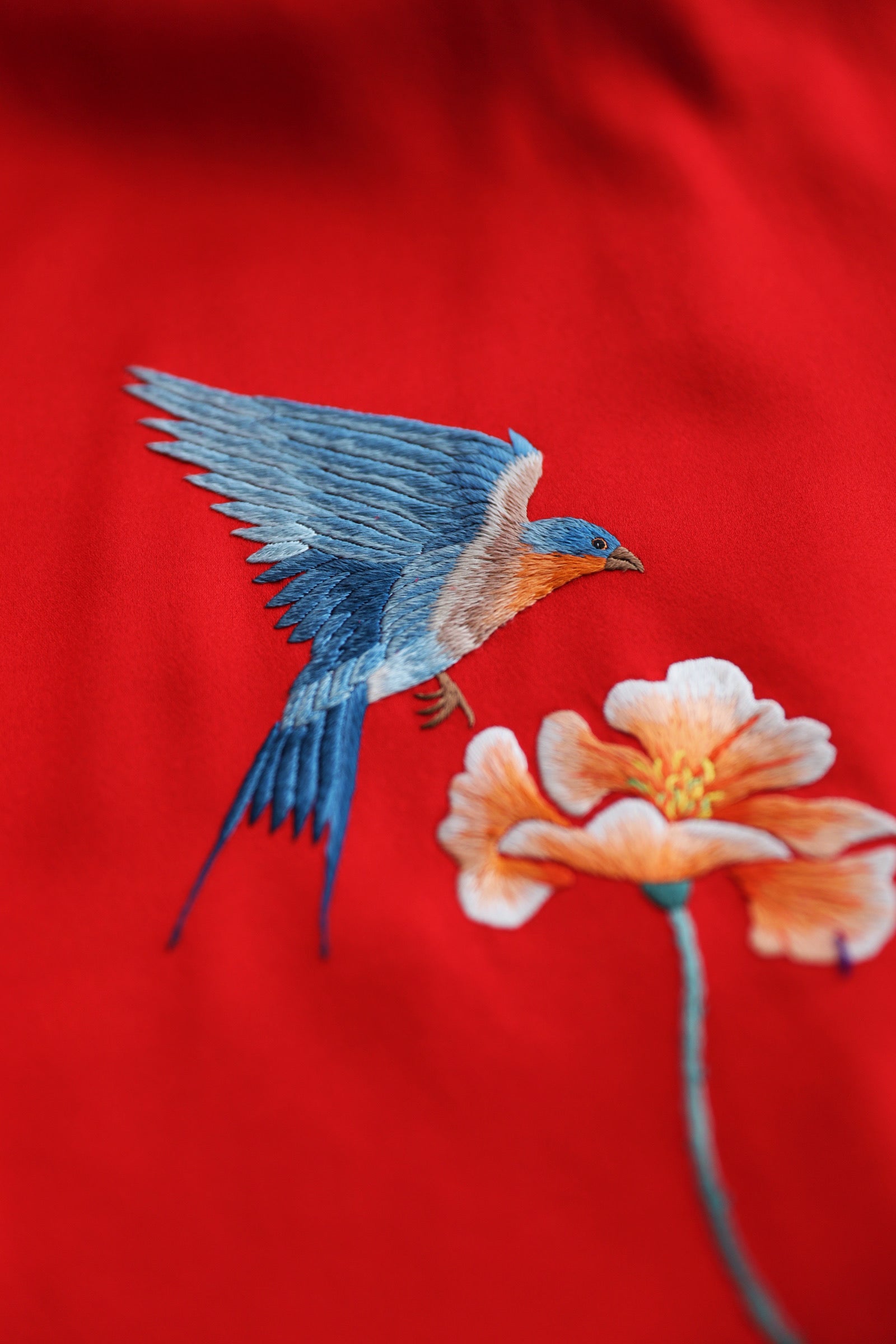 Close-up of a bird embroidery on a red Chinese Qipao wedding dress