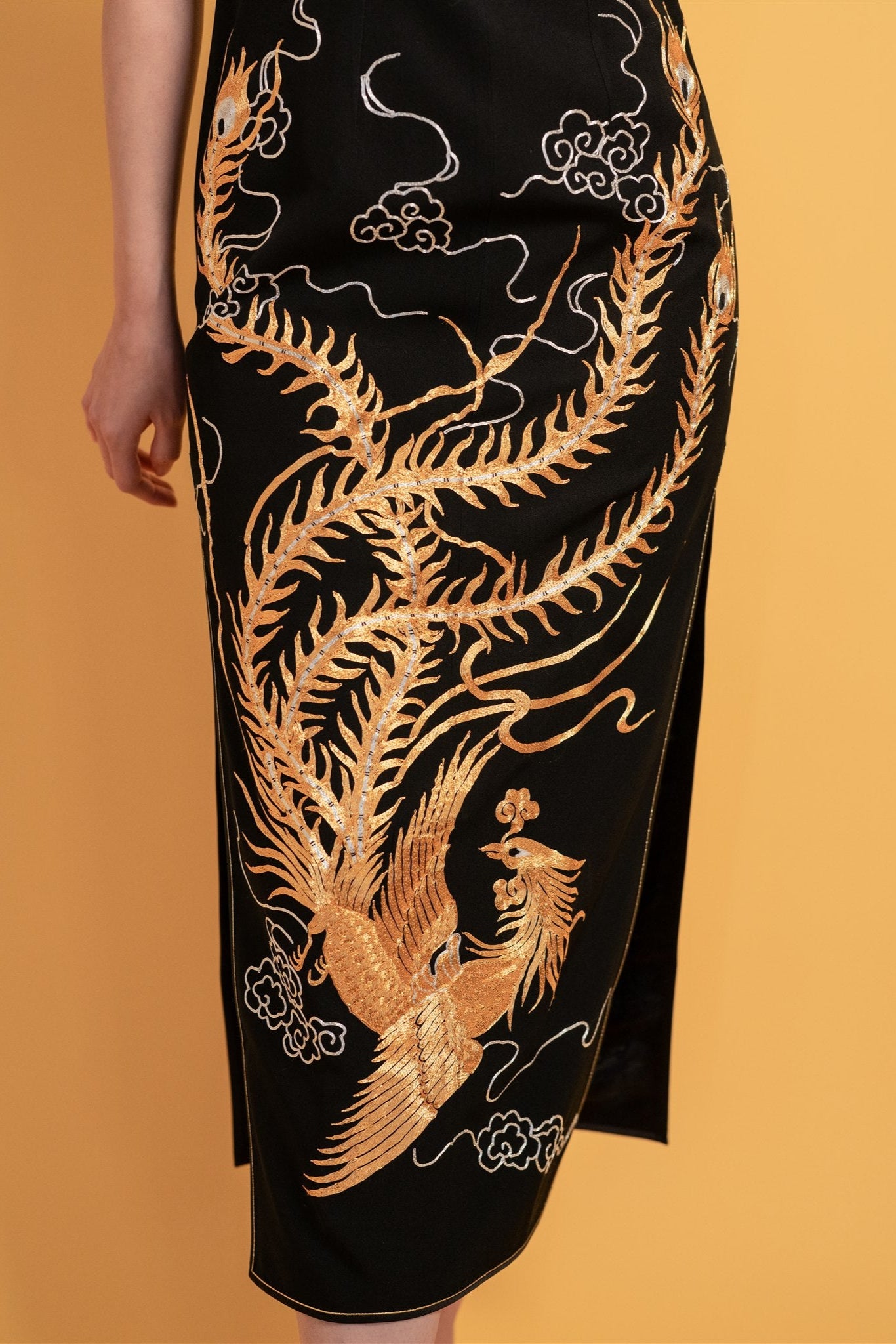 Close-up of gold phoenix embroidery on black cheongsam dress
