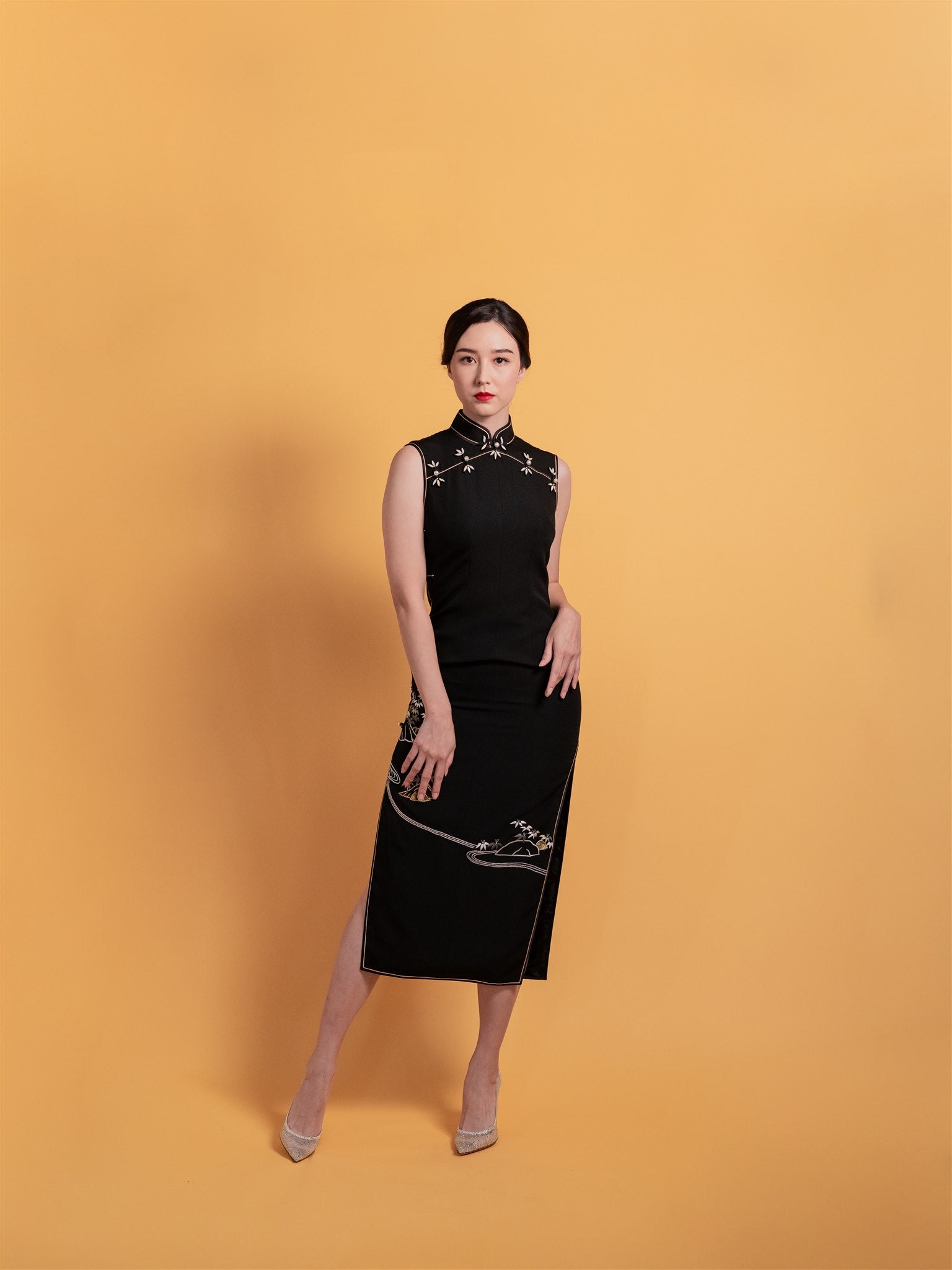 Elegant black silk Qipao/Cheongsam with hand-embroidered bamboo, river, and rocks, featuring a sleeveless, mid-calf length design and mandarin collar.