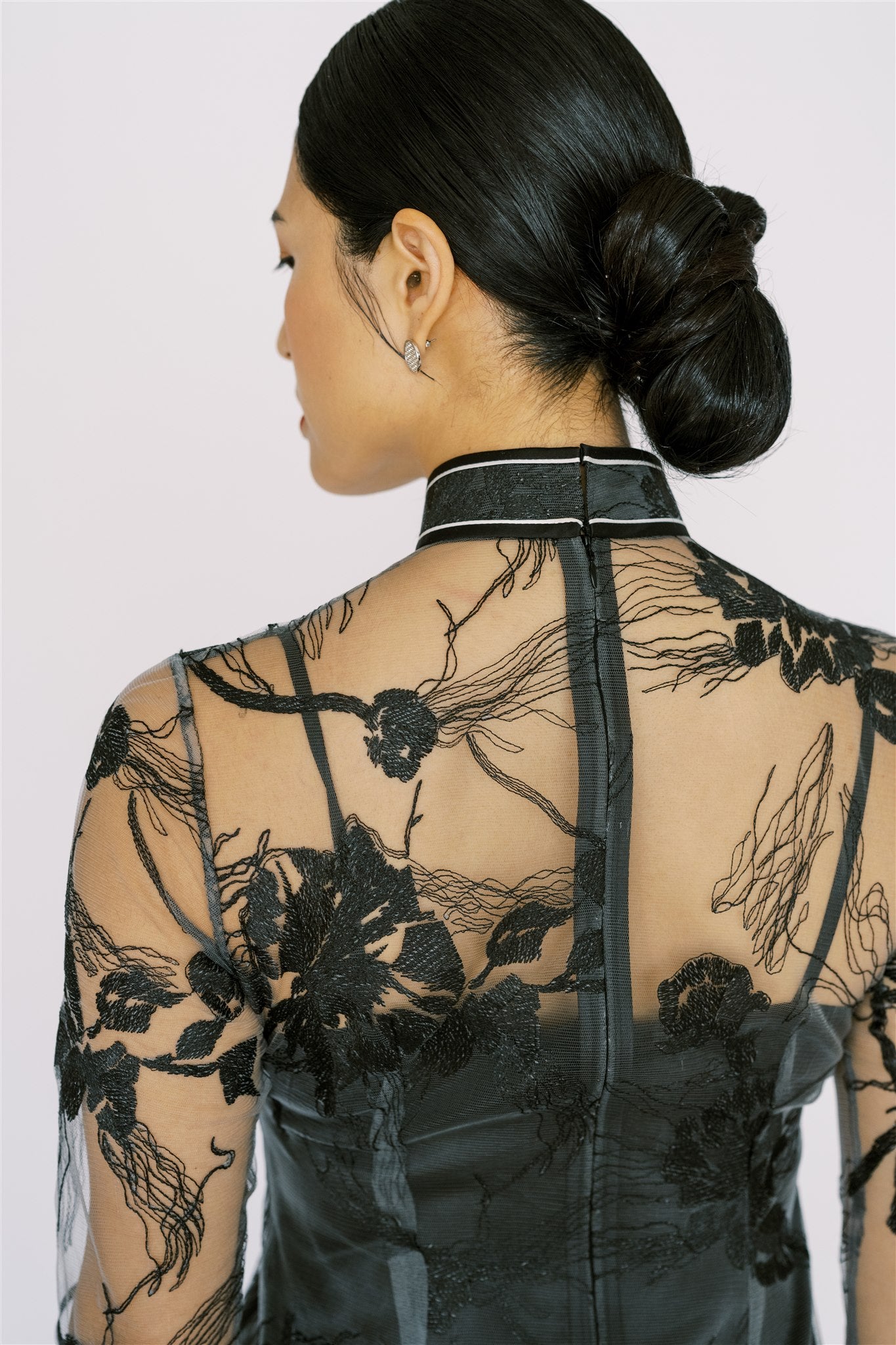 A woman is wearing mandarin collar black lace modern cheongsam