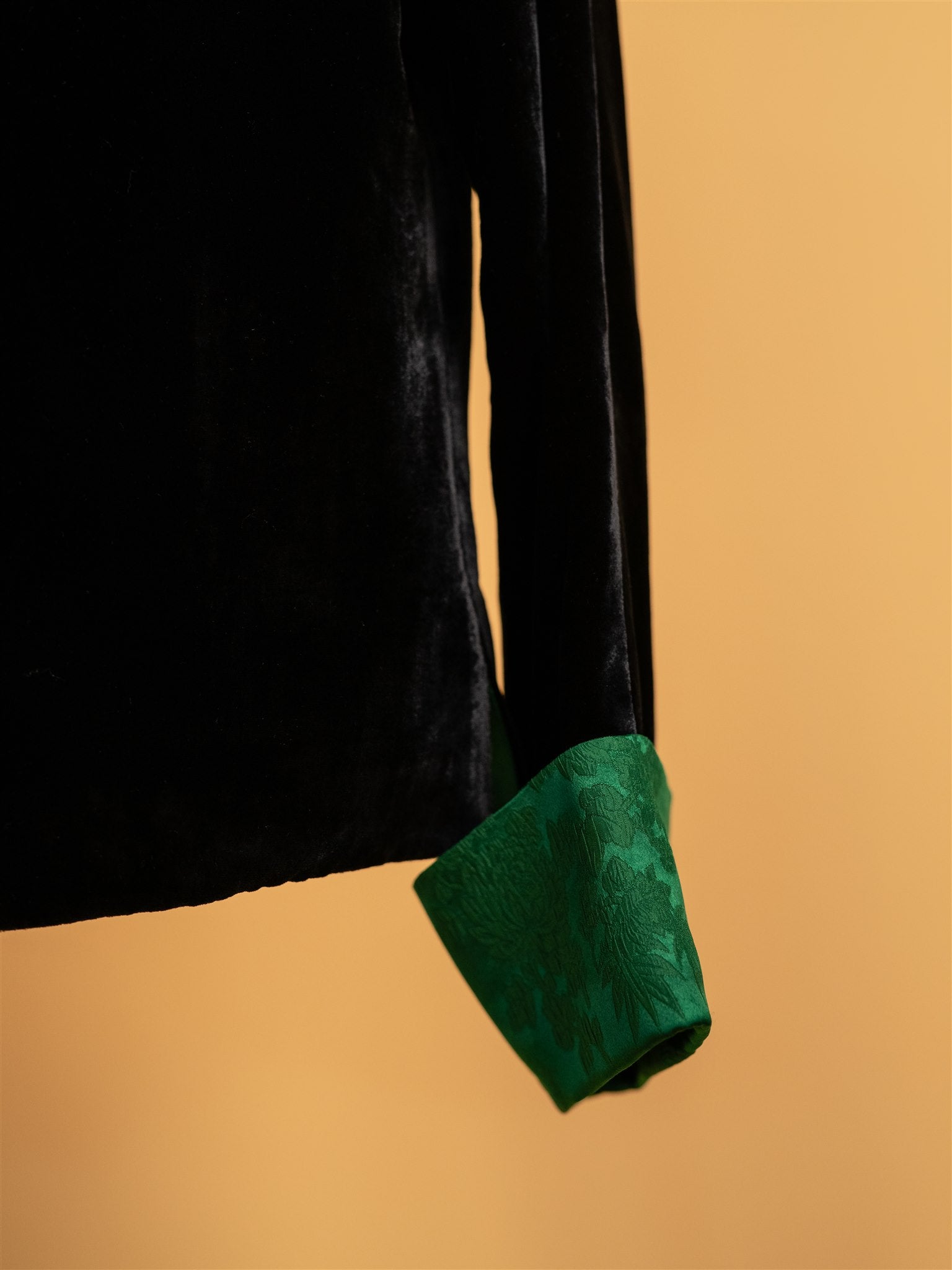 A detailed view of the green silk brocade calf on a black silk velvet tang suit. 