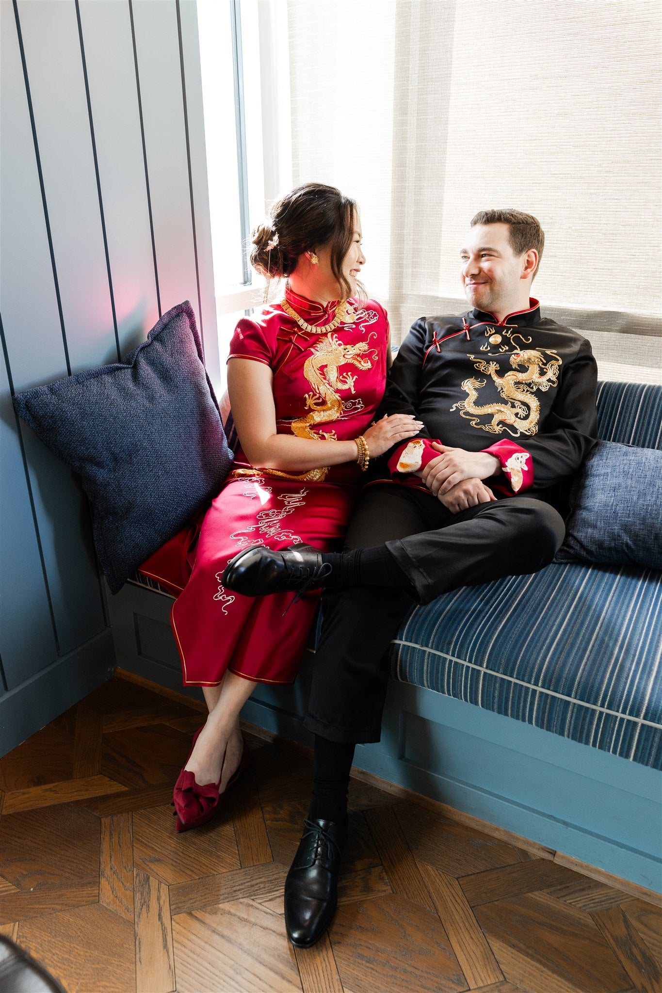 A man wearing a custom-made black silk tang suit for his wedding with wine red silk lining