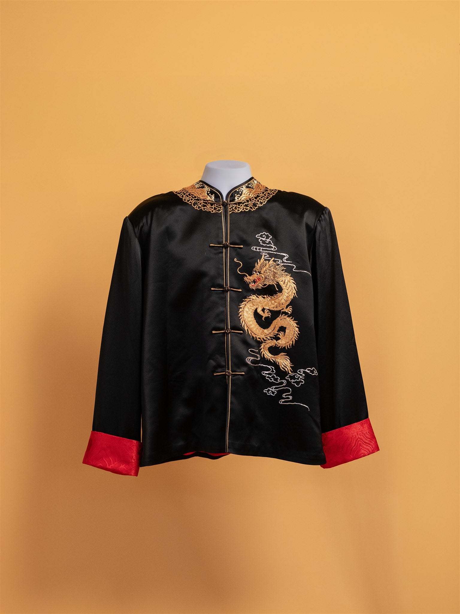 Front view of black Tang suit wedding jacket with gold dragon embroidery.