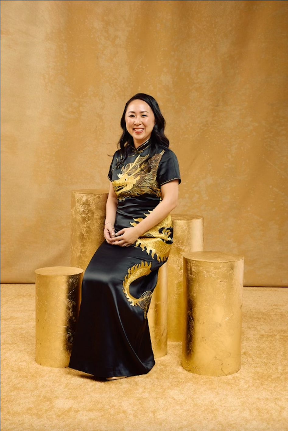 a woman wearing black silk traditional Chinese dress with gold hand-embroidered dragon