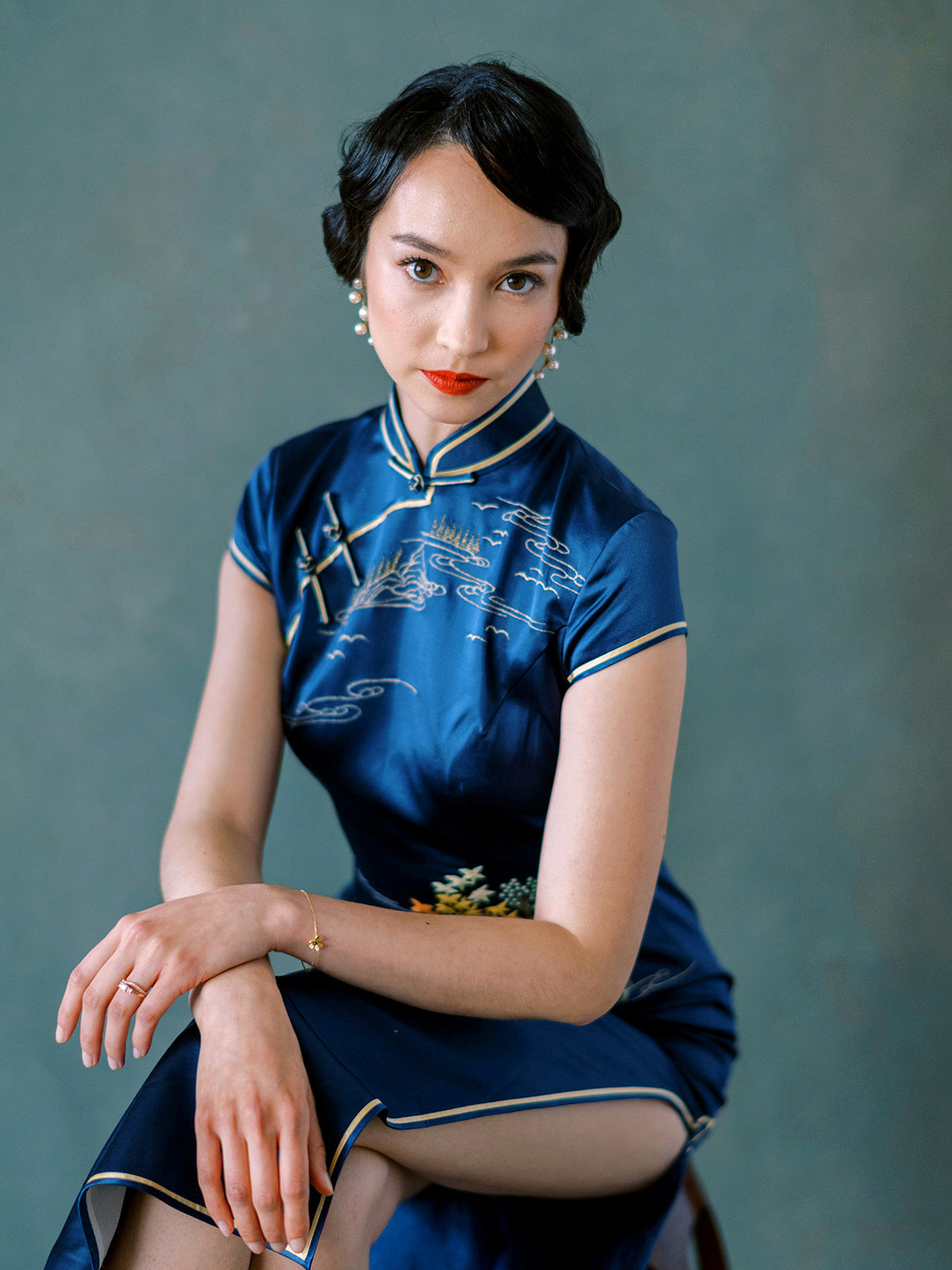 Close-up of traditional blue silk Qipao with Mandarin collar and hand-embroidered neckline