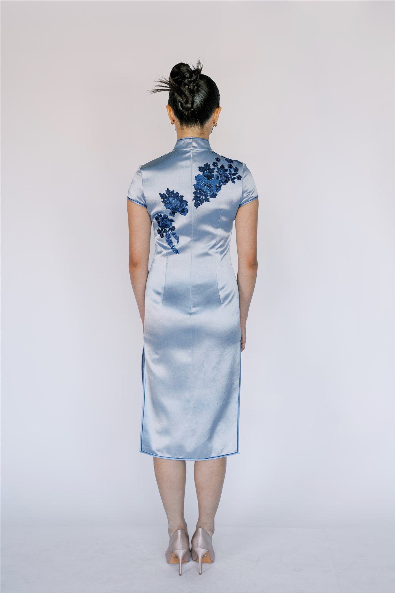 Back view of a blue silk Qipao short dress. 