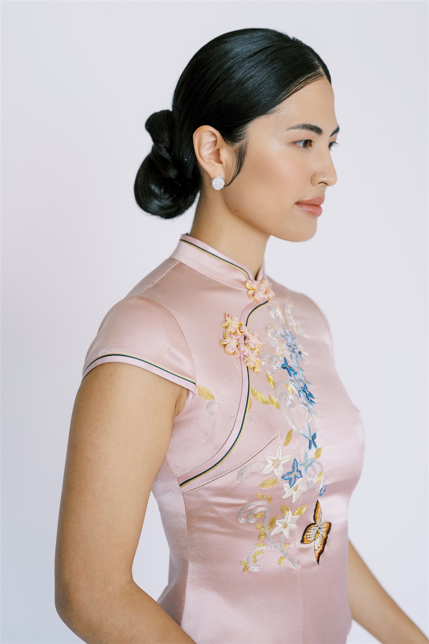 A woman wearing blue trimmed pink silk Qipao