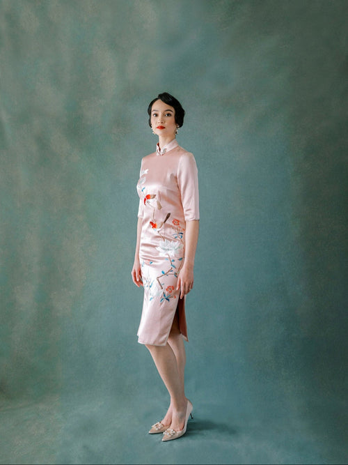 Front view of blush pink silk Qipao dress with magnolia and bird embroidery.