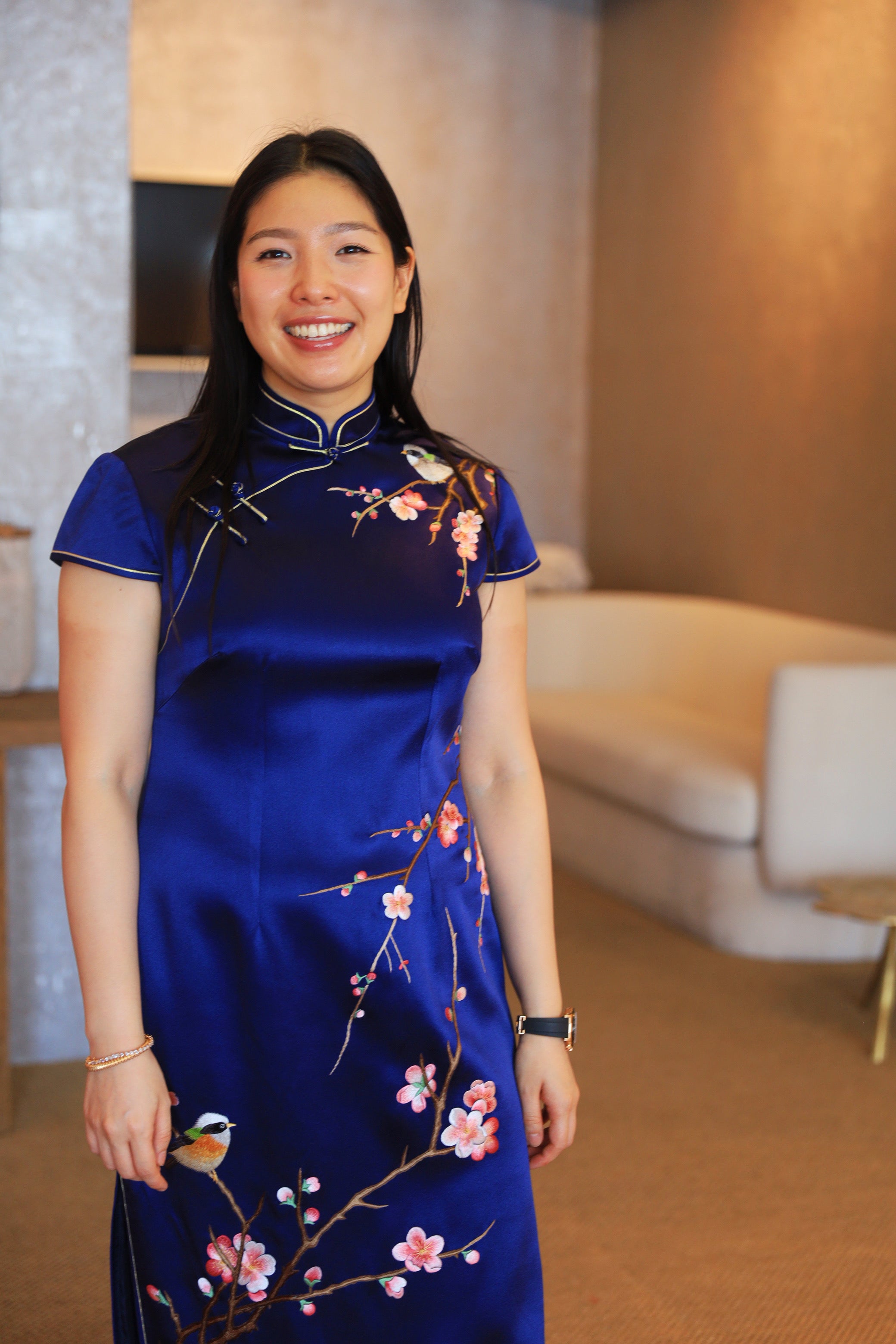 Front view of a navy blue silk Qipao with cherry blossom and bird embroidery. It is a timeless Chinese wedding dress.