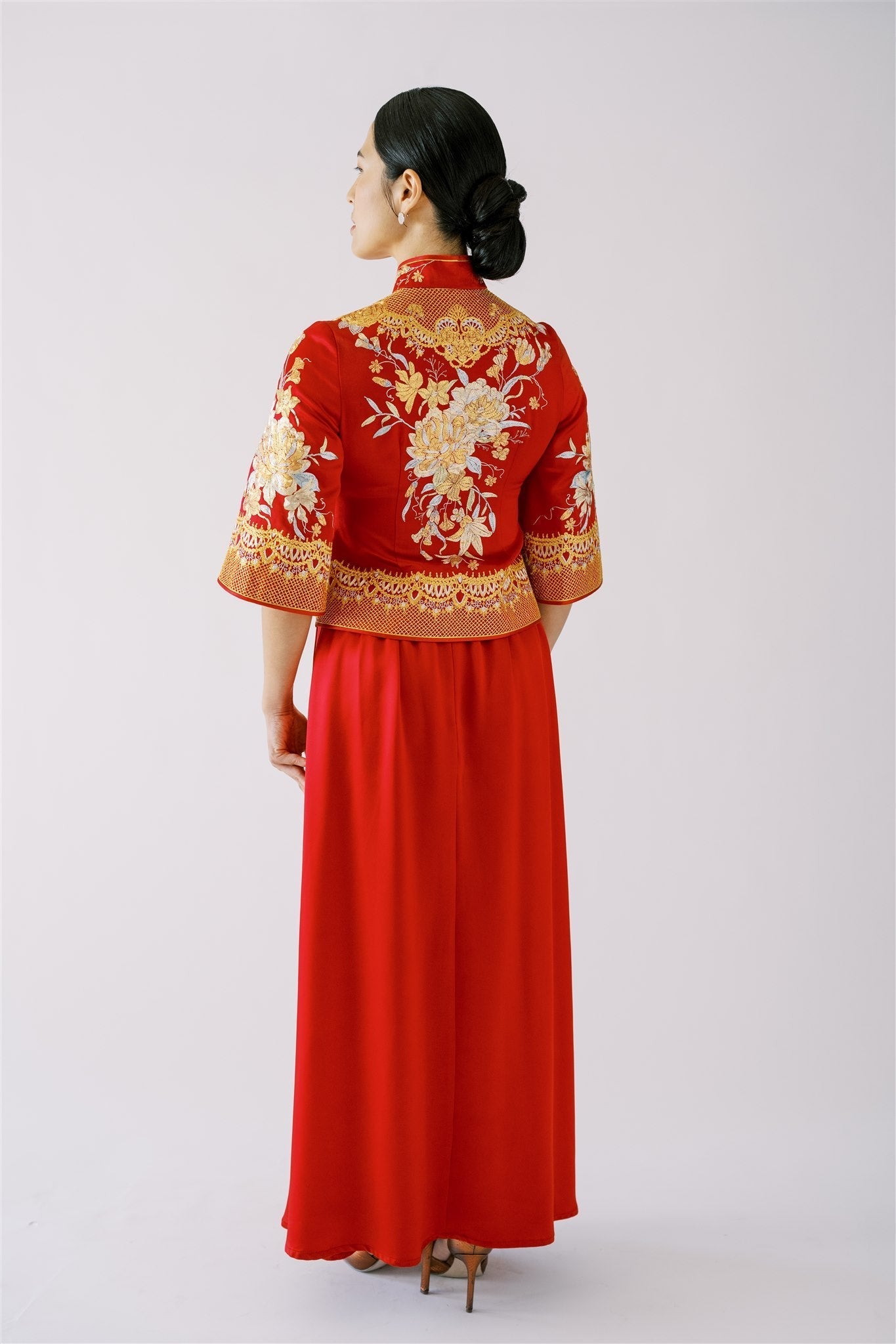 A woman wearing a Xiu He Fu with A-line skirt and a fitted jacket with peony embroidery