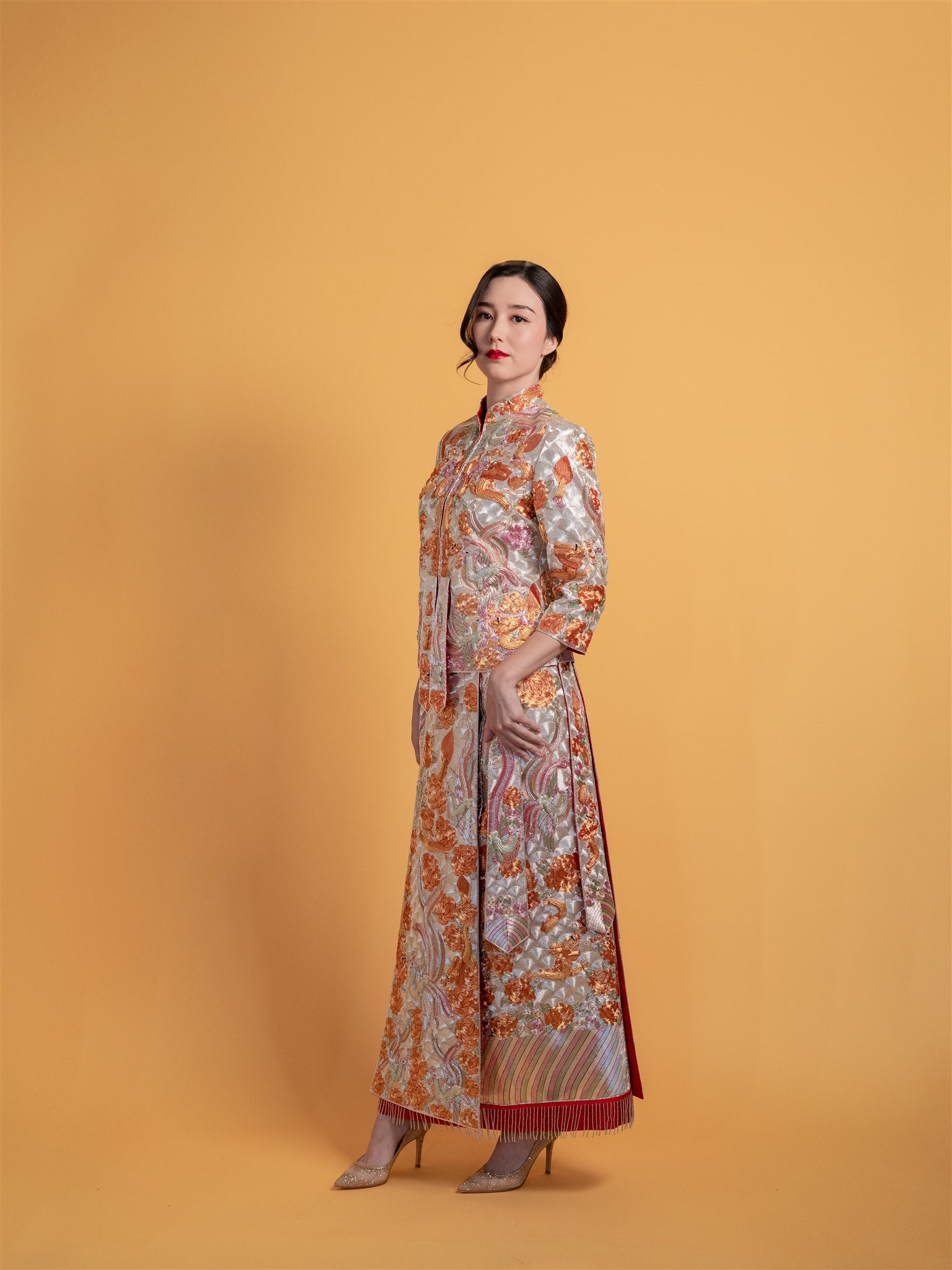 Side view of a Qun Kwa King Kwa wedding dress with silver and gold dragon, phoenix, bats, and full embroidery coverage, ideal for a regal tea ceremony look.