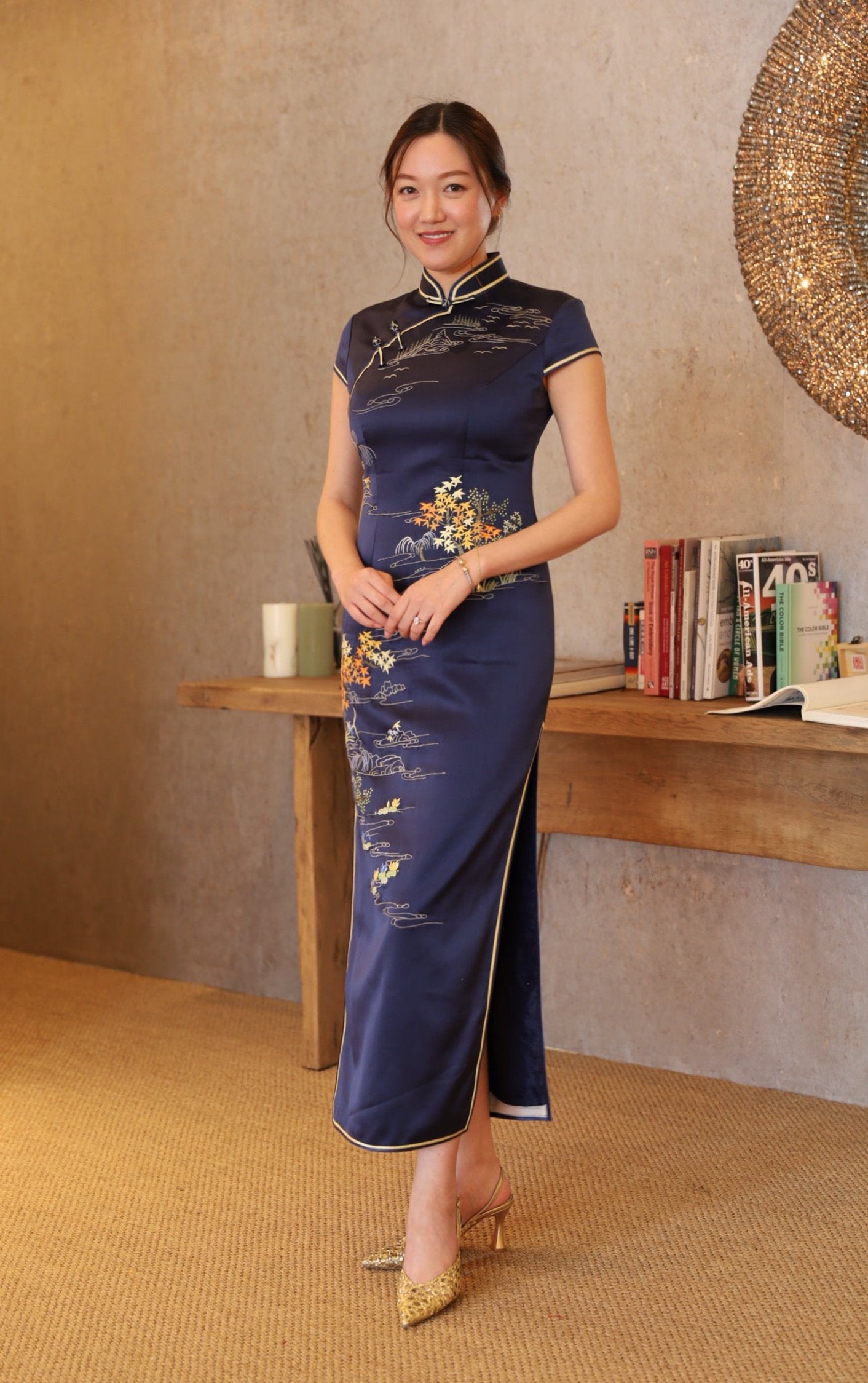 A client wearing the poet on mountain top navy blue silk Qipao with landscaping hand embroidery. 