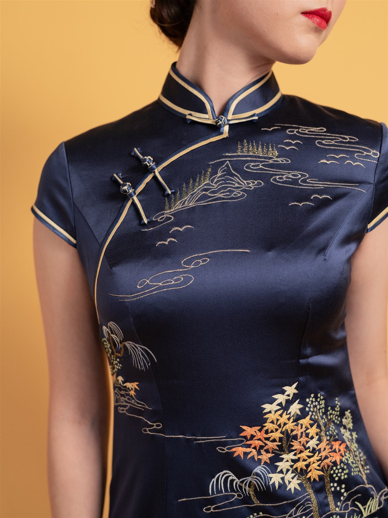 Close-up of Shu embroidery on wedding Qipao, the handcrafted mountain, water and tree motifs on a traditional Chinese dress.