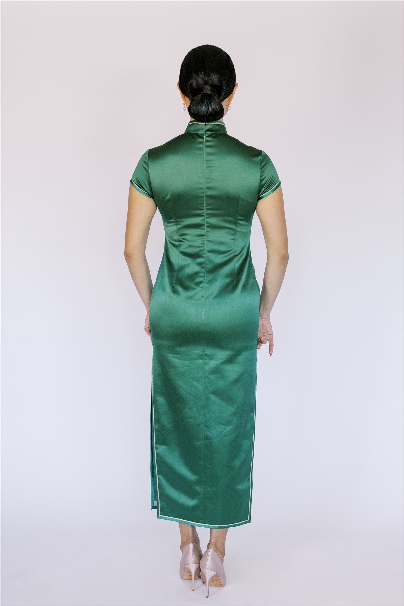 Back view of smooth emerald green silk on traditional Qipao, showcasing the luxurious texture enhancing the timeless look.