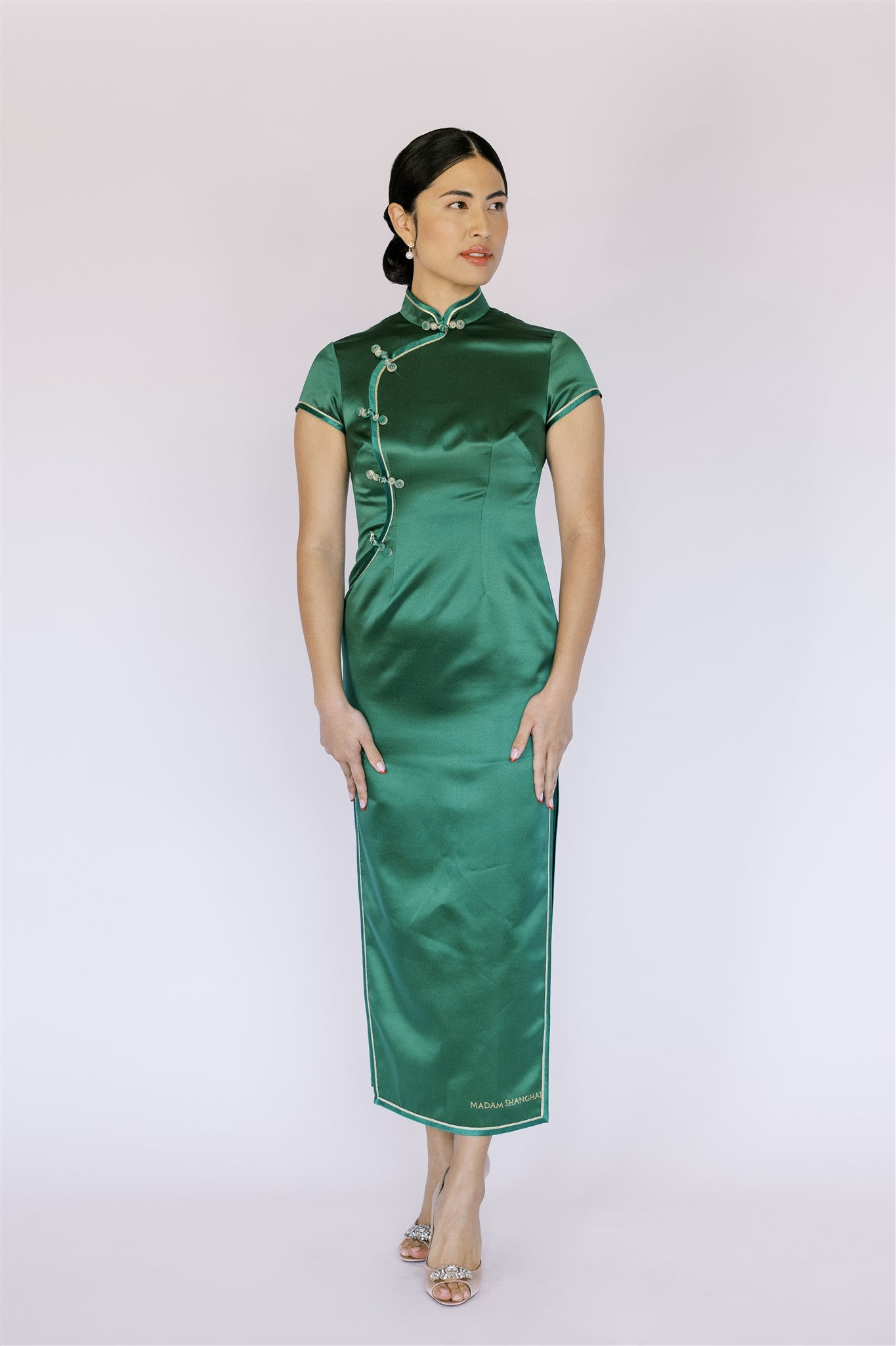 Front view of a classic emerald green Qipao dress. It is a timeless Chinese dress with a traditional Pankou closure.