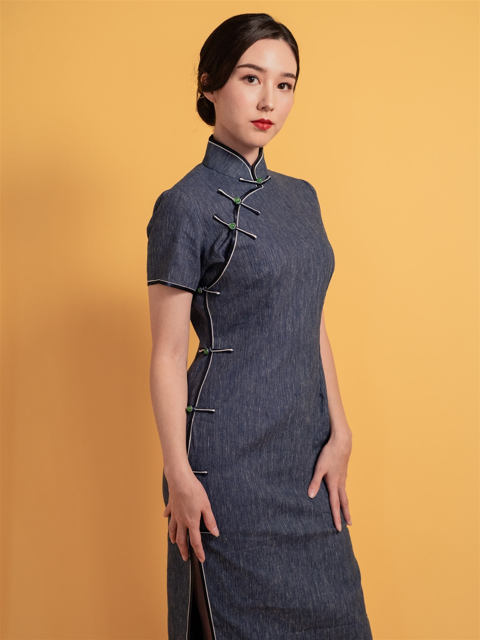 Side view of a classic Qipao dress featuring Japanese indigo cotton with cap sleeves and mid-calf length, inspired by 1930s traditional Chinese dress.