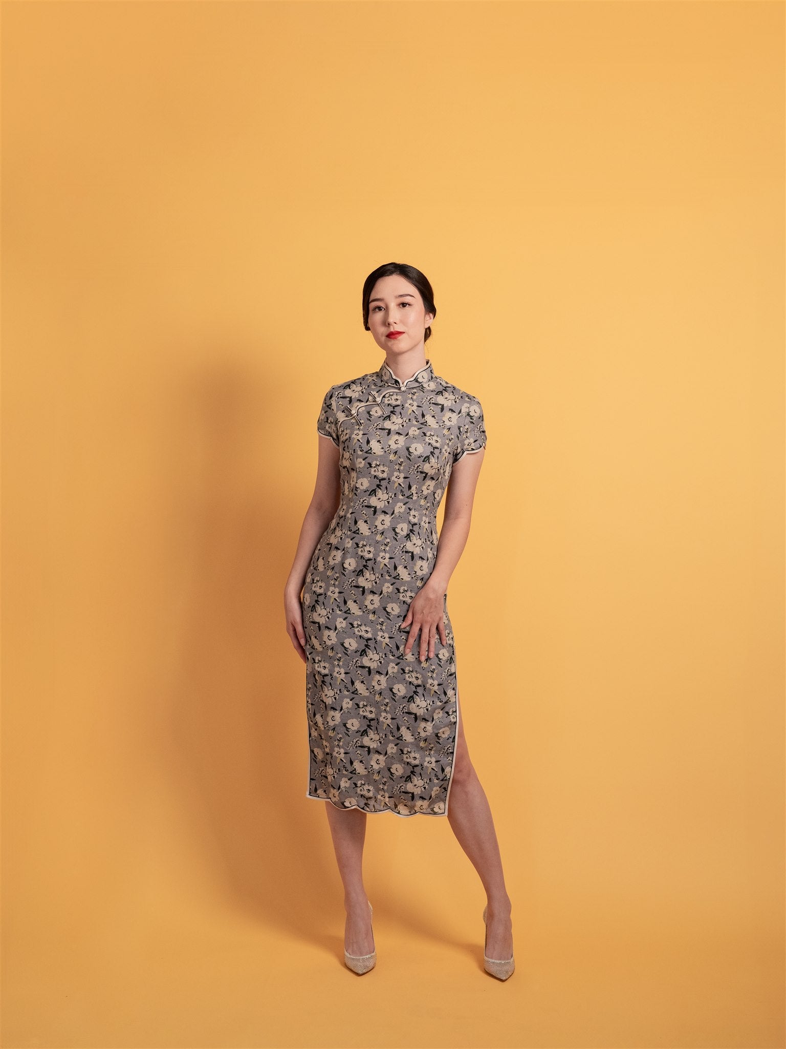 Front view of a classic floral Qipao dress in Japanese cotton, and a light purple and grey Chinese dress with playful waving trim.