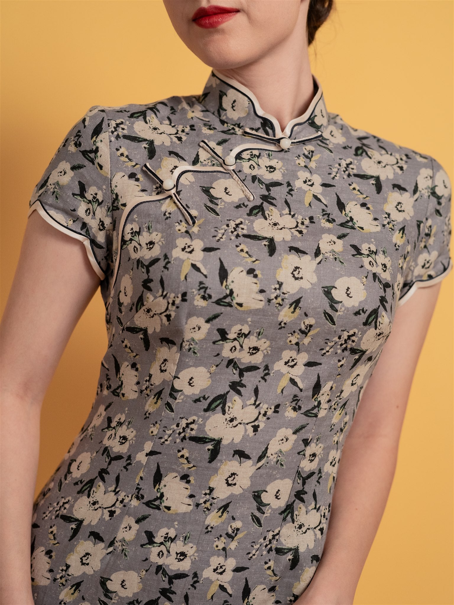 Close-up of floral pattern on Japanese cotton Qipao, a delicate light purple and grey design with vibrant detailing.