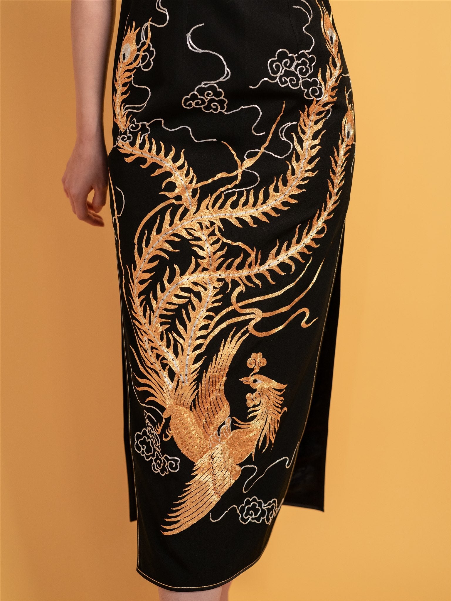 Detailed view of a waving phoenix embroidery highlights the flowing bottom shape of the Qipao, adding elegance and rich cultural symbolism.