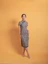 Front view of a vintage linen Qipao dress, a classic Chinese dress with a traditional mandarin collar and piping details.