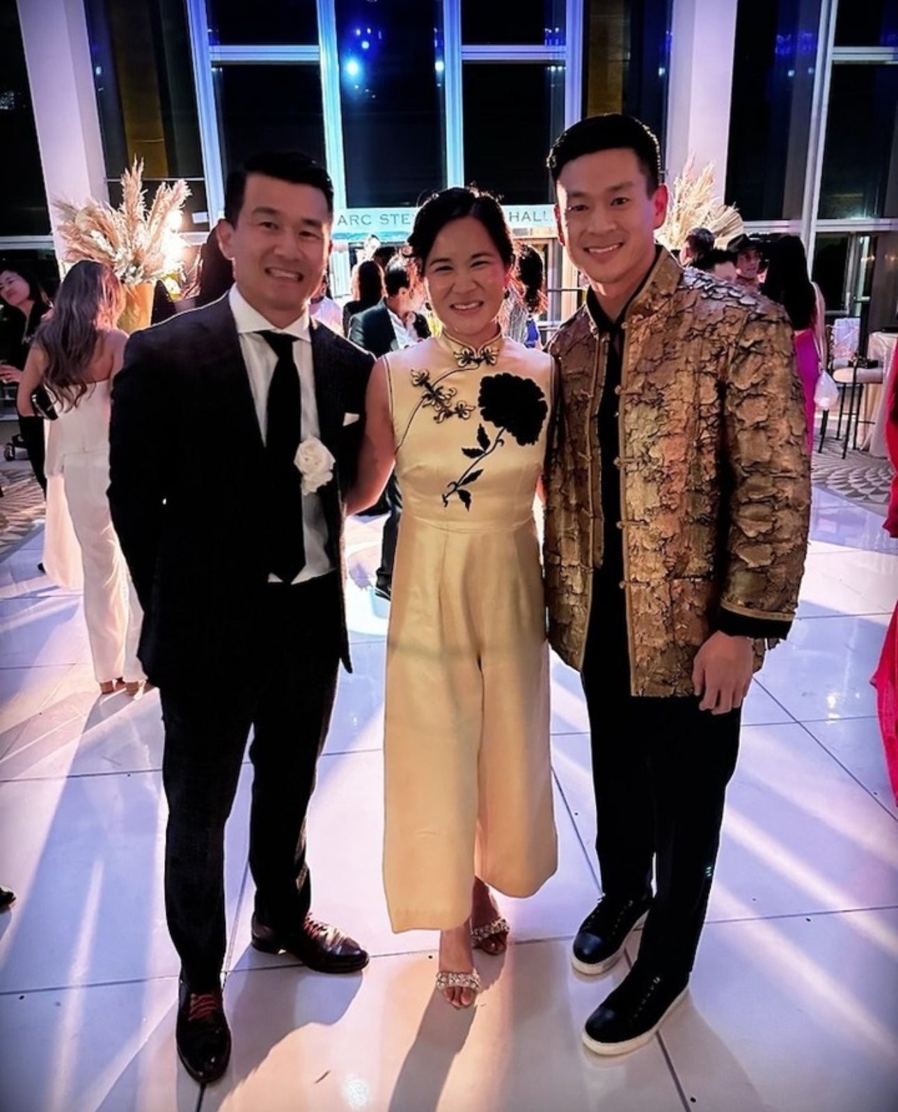 Client wearing a gold leaf textured Tang suit at a formal event in Los Angeles, showcasing modern Chinese jacket elegance.